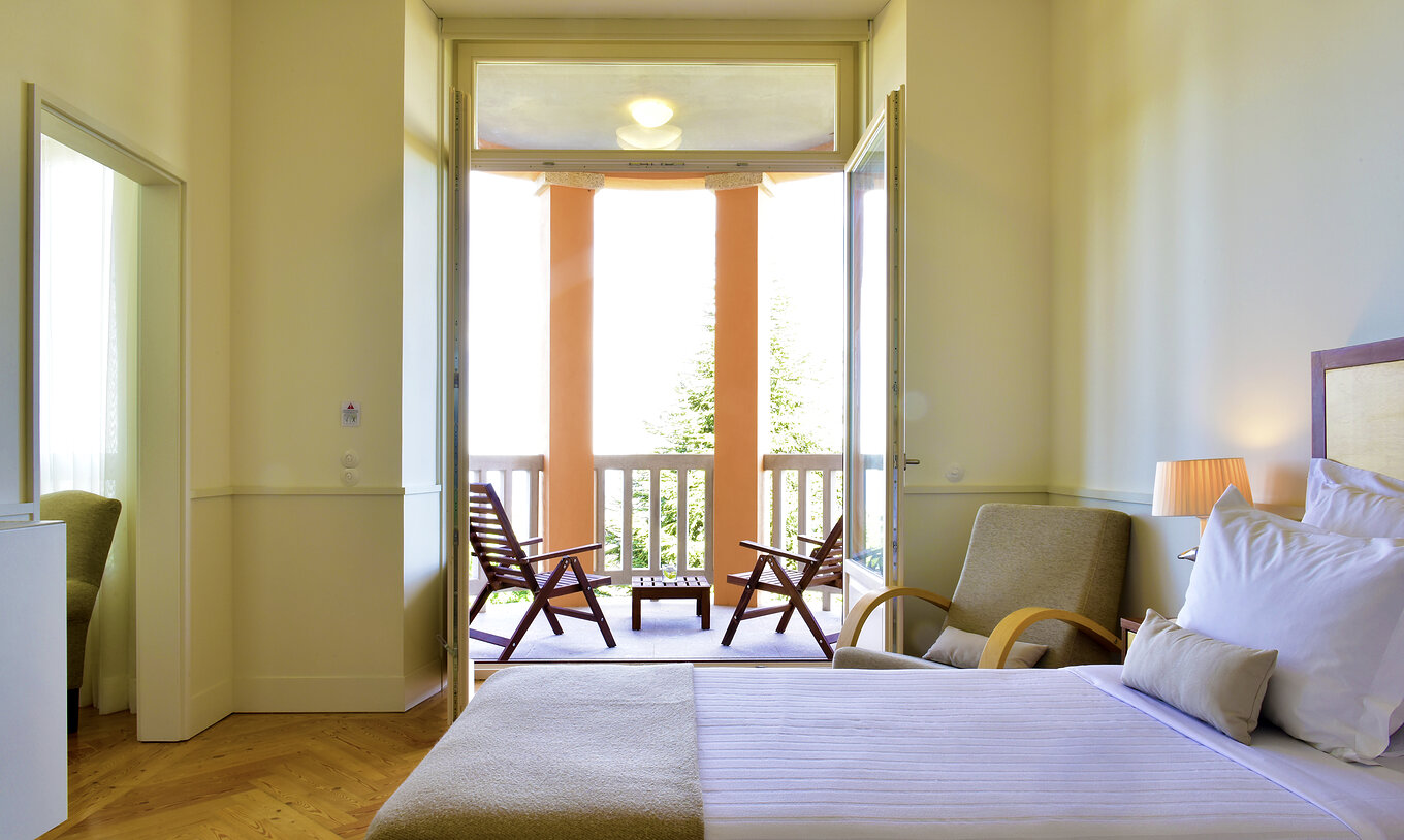 The Superior Torrão of The Pousada Serra da Estrela has two beds and a balcony with two chairs and a panoramic view