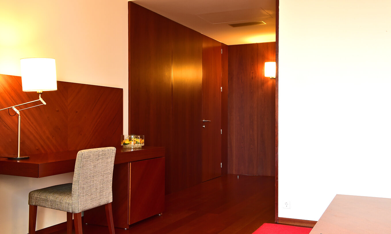 The Classic Room of the Pousada Viseu has a desk with chair and lamp, and a wardrobe