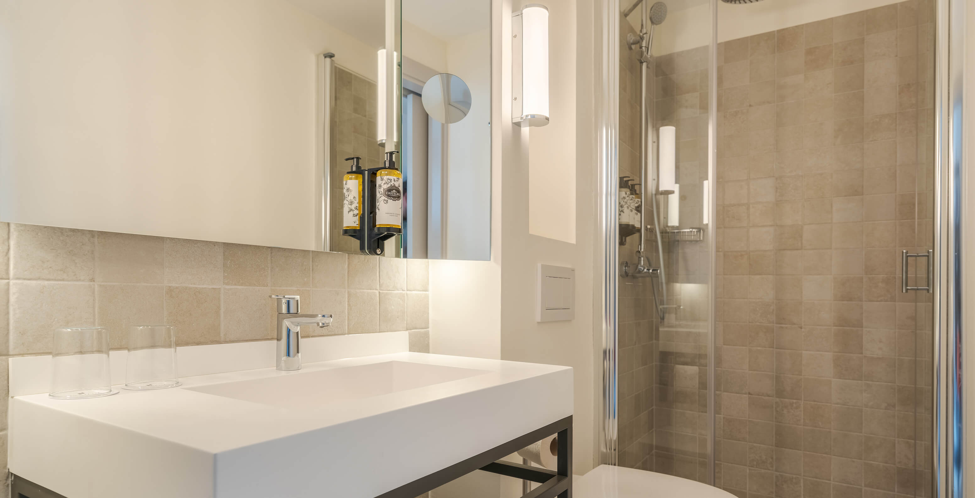 The Large Family room at Pousada Alfama has a bathroom with a walk-in shower, a white toilet, and a sink with a mirror above