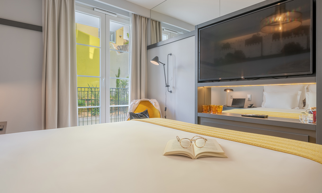 The Comfort Balcony at Pousada Alfama has a large TV in front of the double bed and next to the window