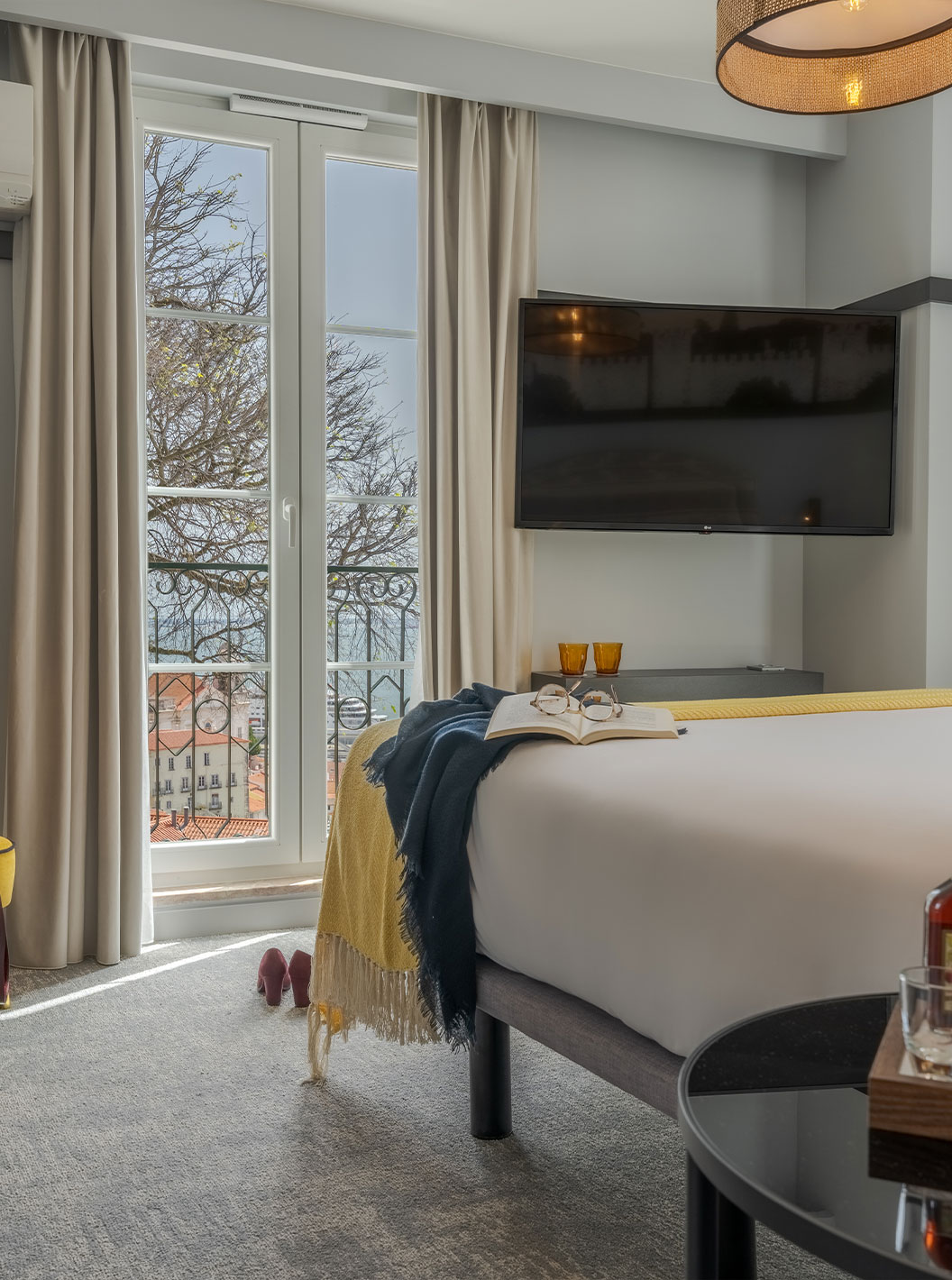 The Large Family Premium room at Pousada Alfama has a TV, an armchair and a window with view of the Portas do Sol lookout