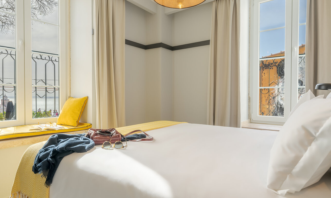 The Large Family room at Pousada Alfama includes a double bed with a river view and a built-in window bench