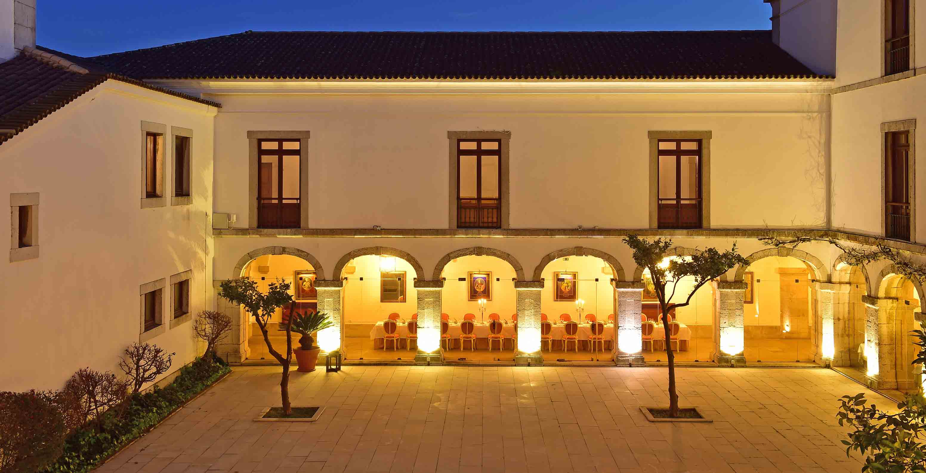 The Pousada Castelo Palmela, a hotel in Palmela, has an interior patio with trees and surrounded by cloisters