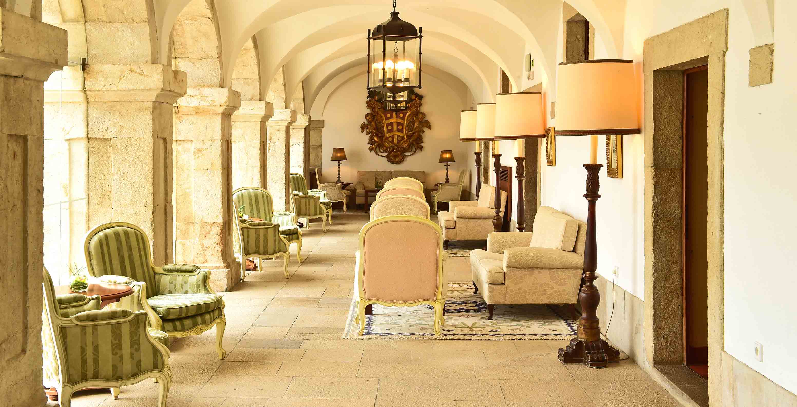 The Pousada Castelo Palmela, a hotel in Palmela, has corridors with cloisters, sofas, and armchairs