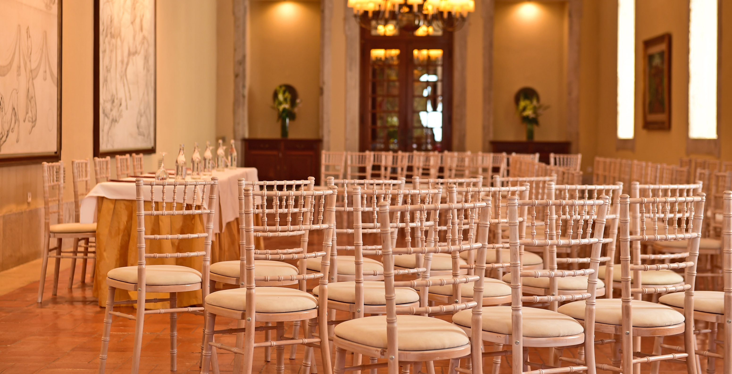 Conference room at Pousada Castelo Palmela, hotel in Palmela, with several chairs, paintings, and flower vases