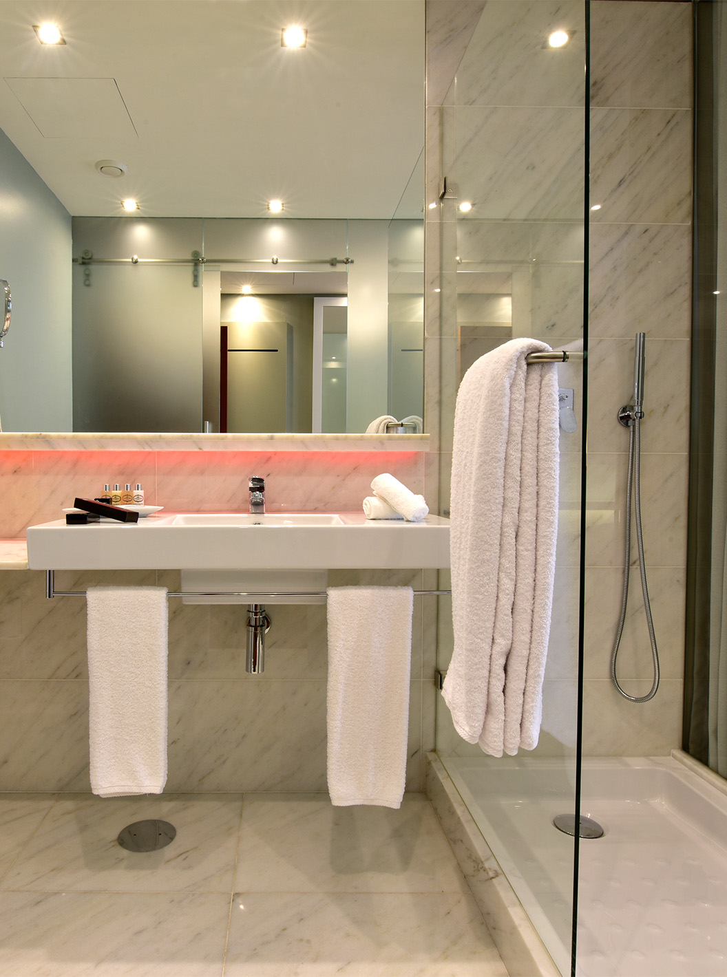 The Cozy Queen Size Bed of The Pousada Lisboa Praça do Comércio has a bathroom in white tones, shower, and red LEDs