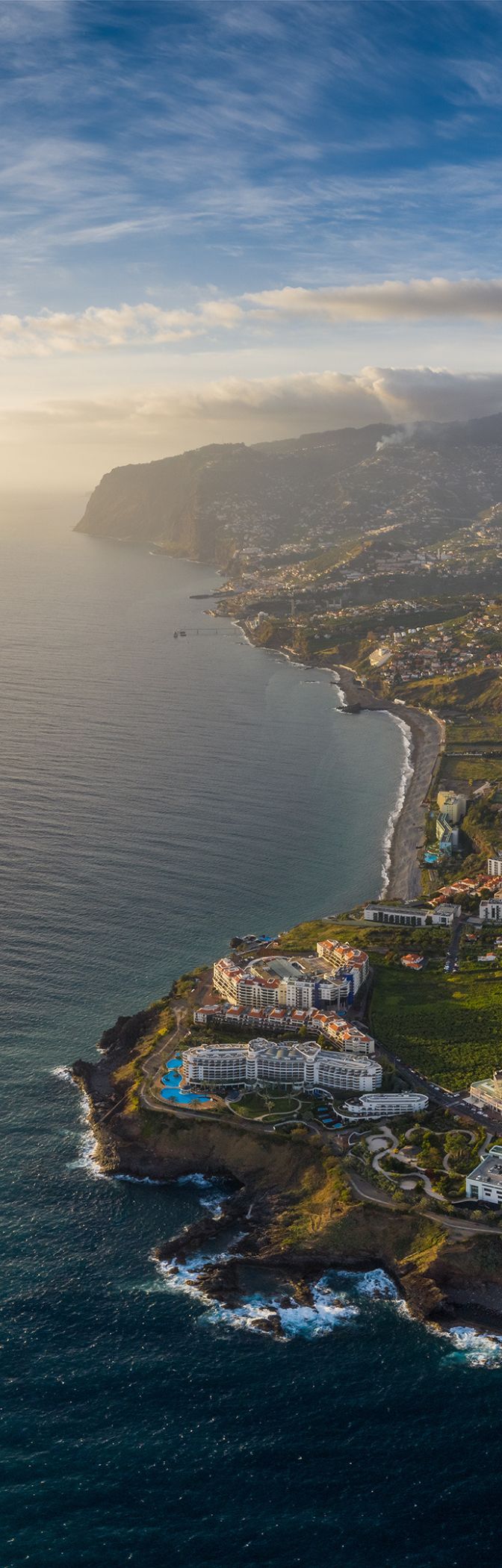 Aerial view of the city of Funchal in Madeira, with a dense urban areas, and mountains in the background
