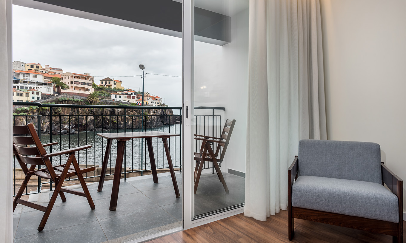 The Deluxe Superior Family Bay View Room at Pestana Churchill Bay has a balcony with a sea view and a table with chairs