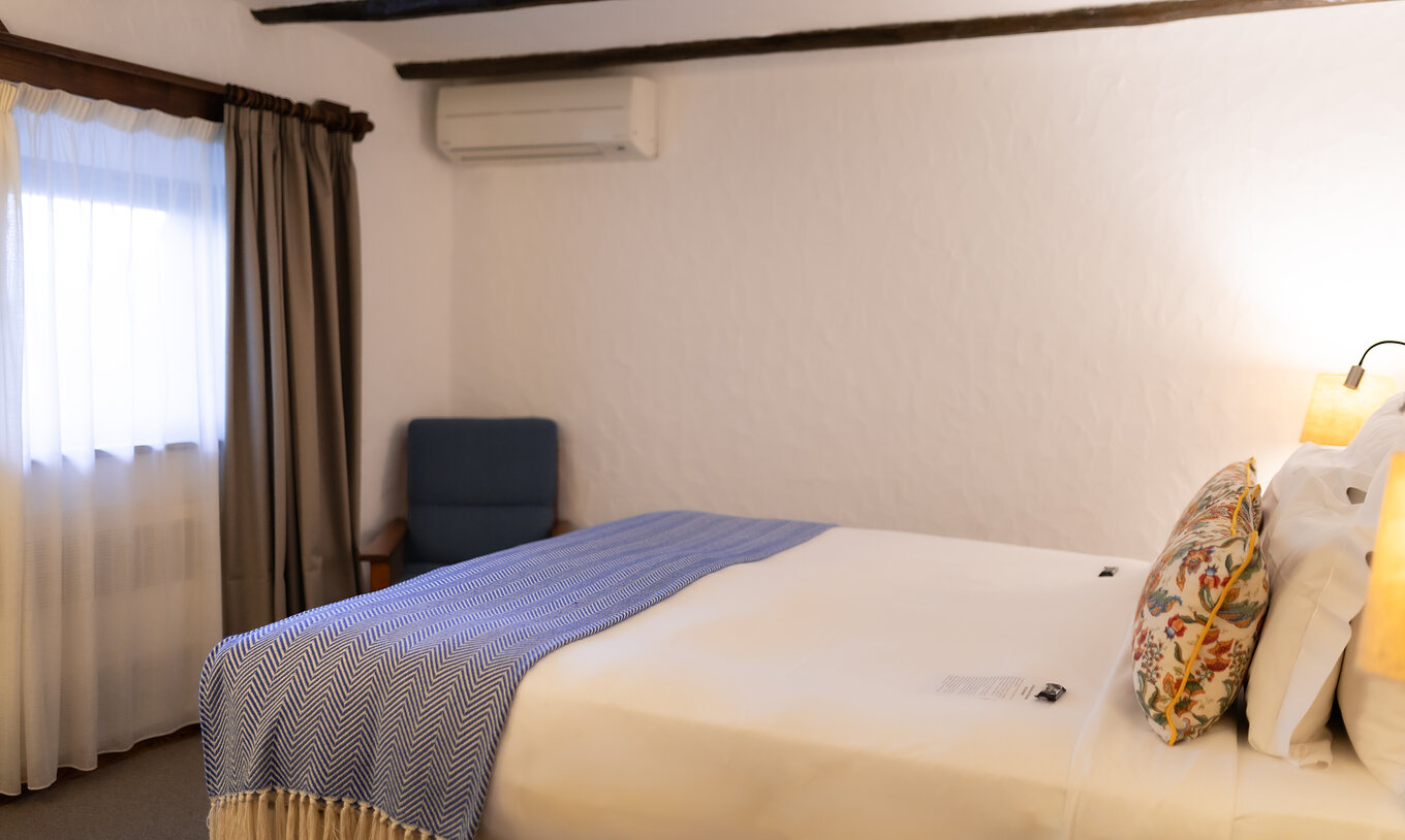 The Classic Room at Pousada Caniçada - Gerês has a double bed, air conditioning, and a window with curtains