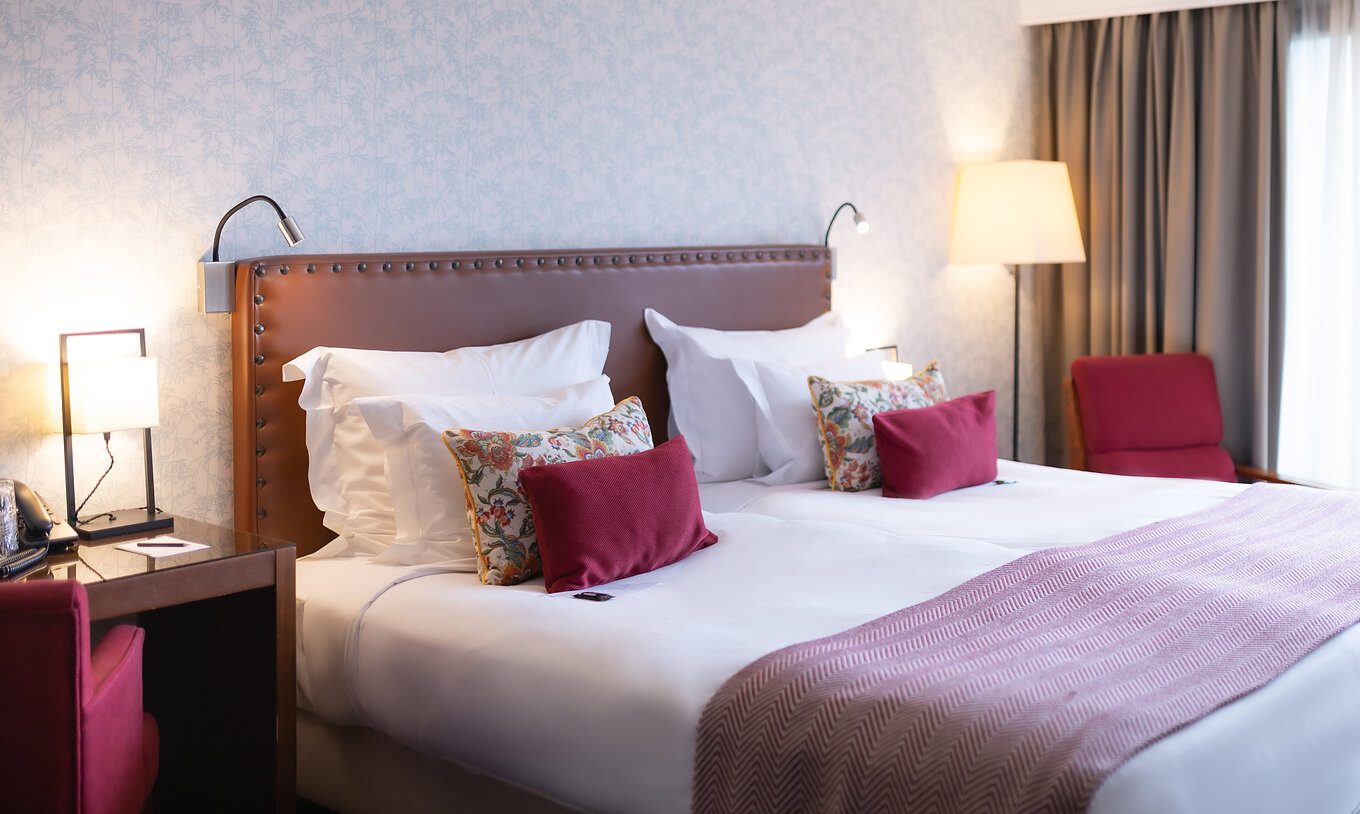 The Large Family Room at Pousada Caniçada - Gerês has a double bed, a bedside table, and an armchair