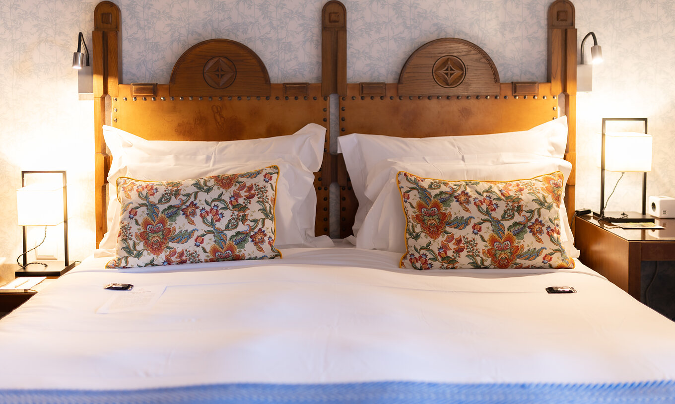 The Standard Suite at Pousada Caniçada - Gerês has a double bed with a wooden headboard and floral wallpaper