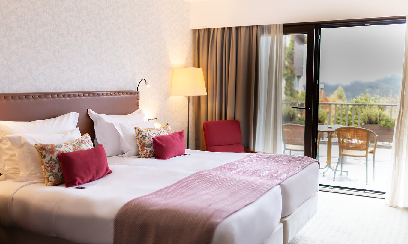 The Superior Terrace Room at Pousada Caniçada - Gerês has two beds and a balcony with a view of the Serra do Gerês