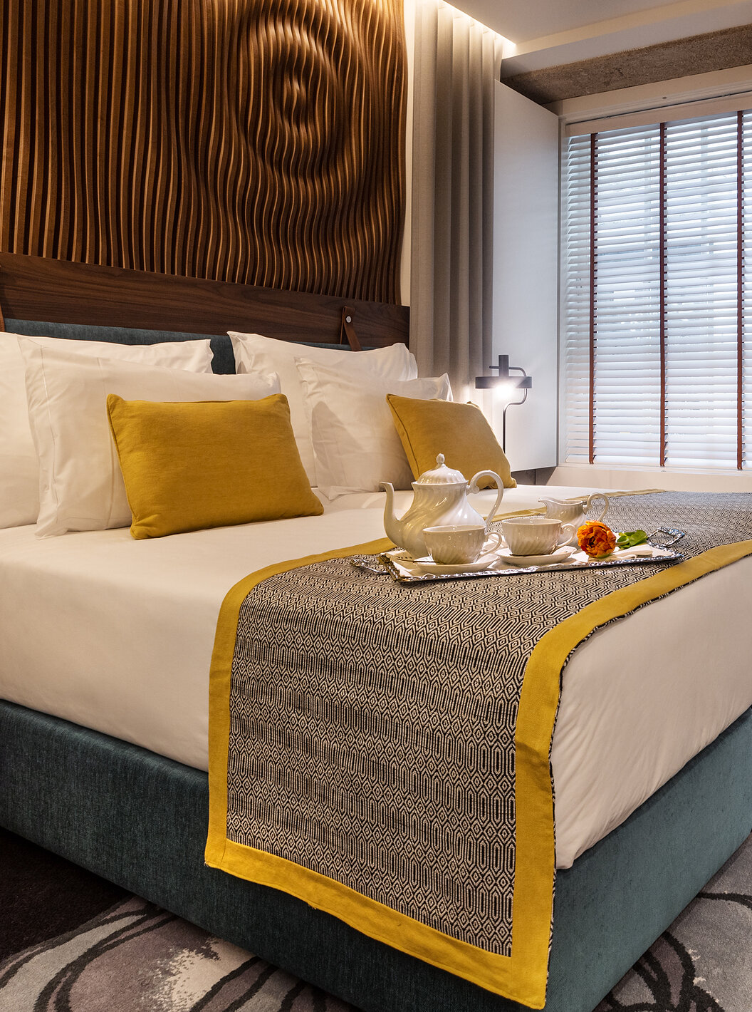 The Classic Room of The Porto Inn - Rua das Flores has a turquoise double bed, white sheets, and a wooden headboard