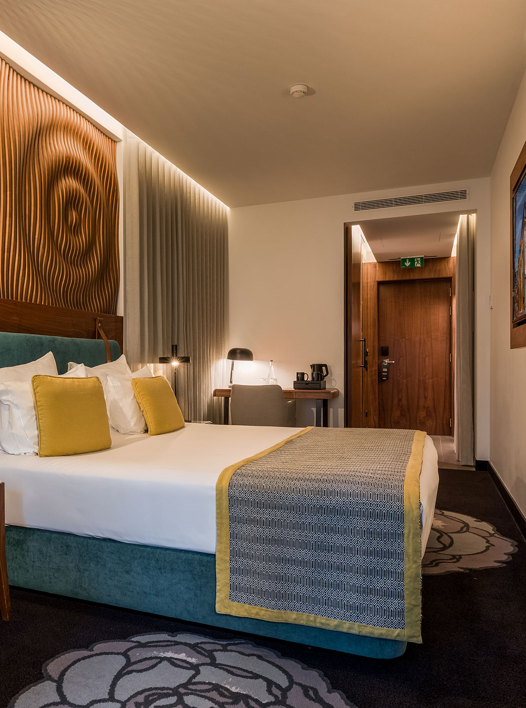 The Superior Family at Pousada Porto - Rua das Flores has a double bed with bedside tables and a grey sofa.