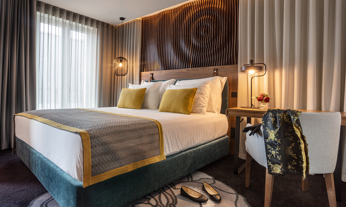 The Superior Room of The Porto Inn - Rua das Flores has a turquoise double bed, white sheets, and a wooden headboard