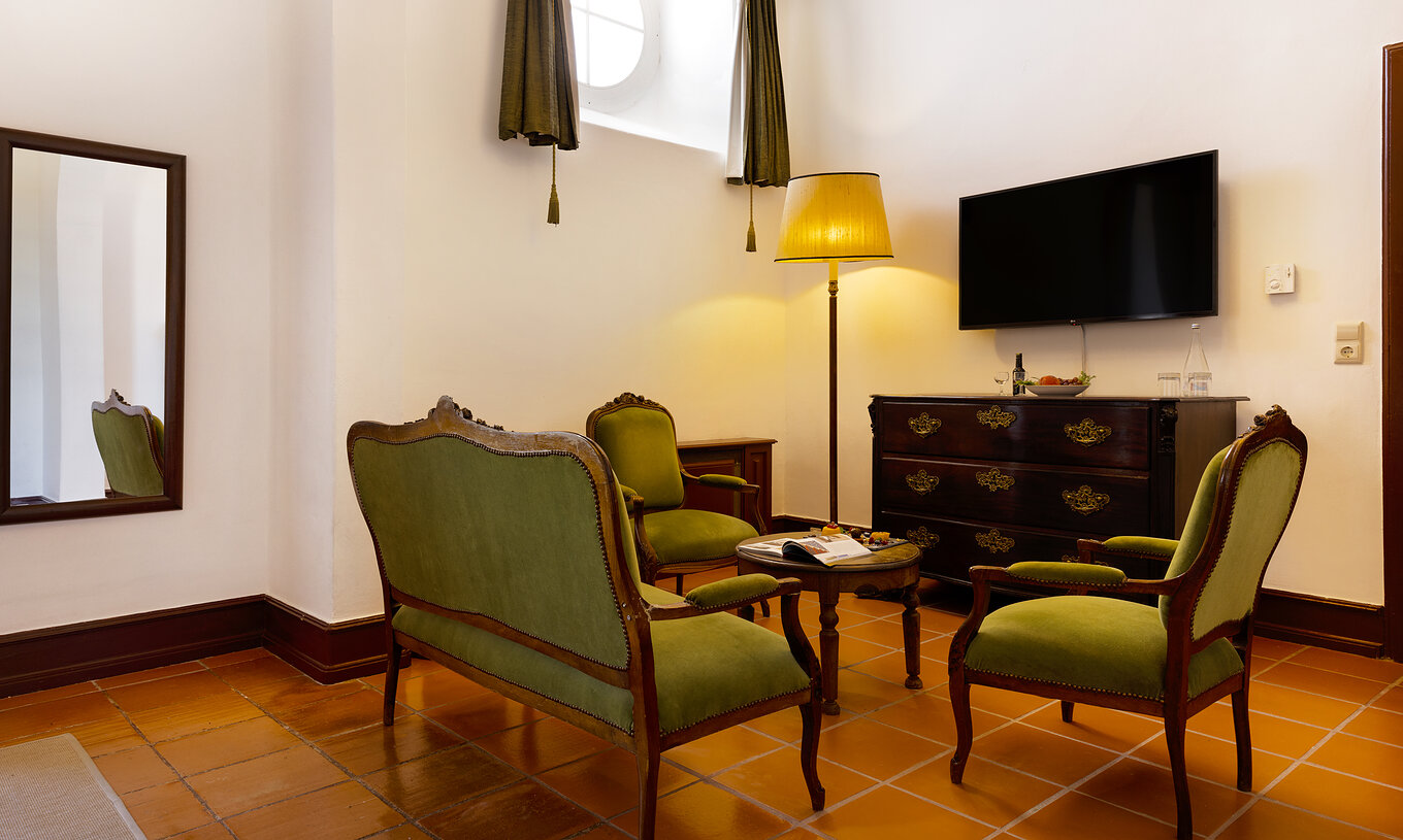 The Junior Suite has a living room with sofas, a mirror and a TV at Pousada Castelo Estremoz
