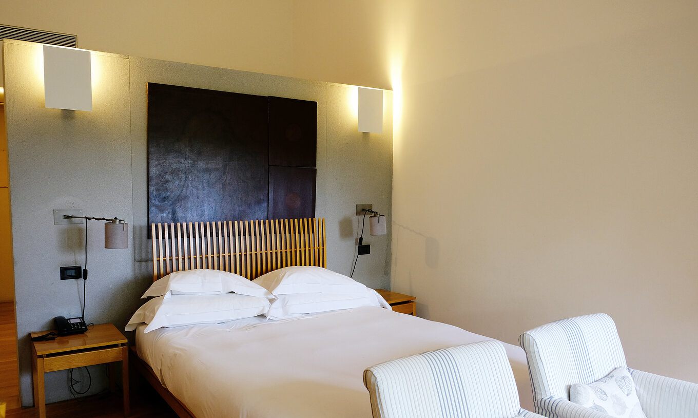 The Family Room of The Pousada Convento Arraiolos has a double bed with bedside tables and two armchairs