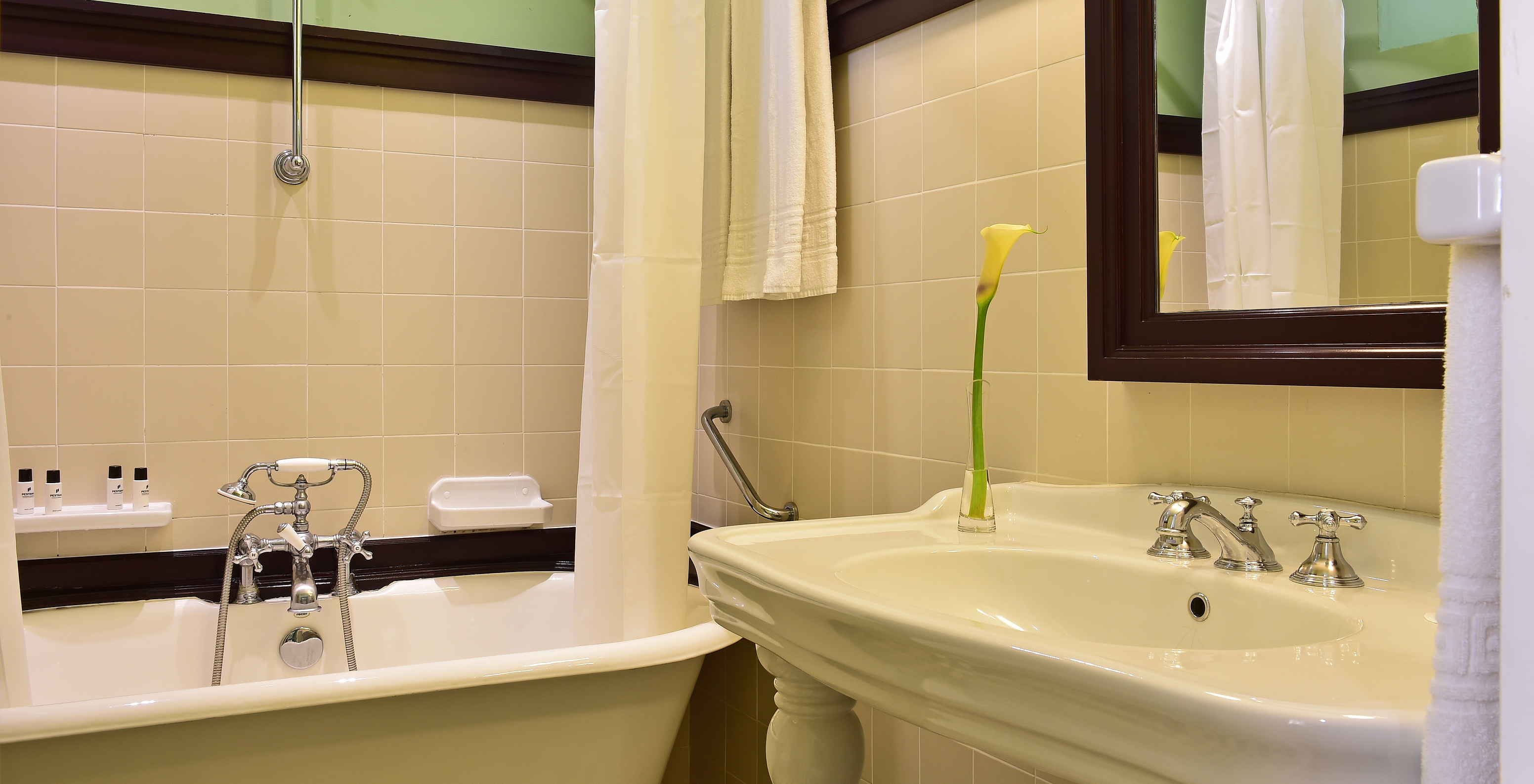 The Superior Family of The Pousada Convento Évora has a bathroom with a sink and a bathtub with a curtain