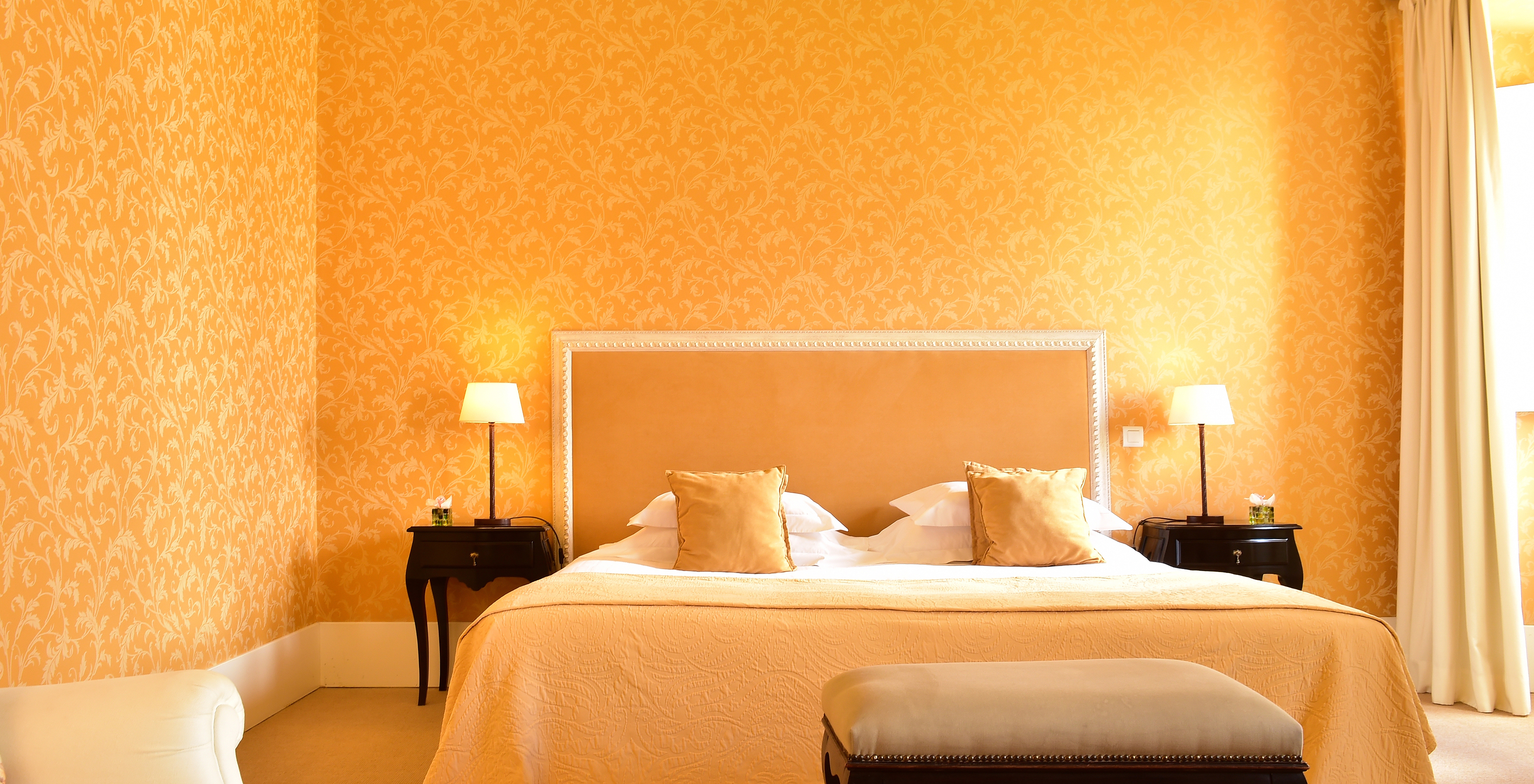 The Master Suite of The Pousada Convento Évora has a double bed with two bedside tables and a bench