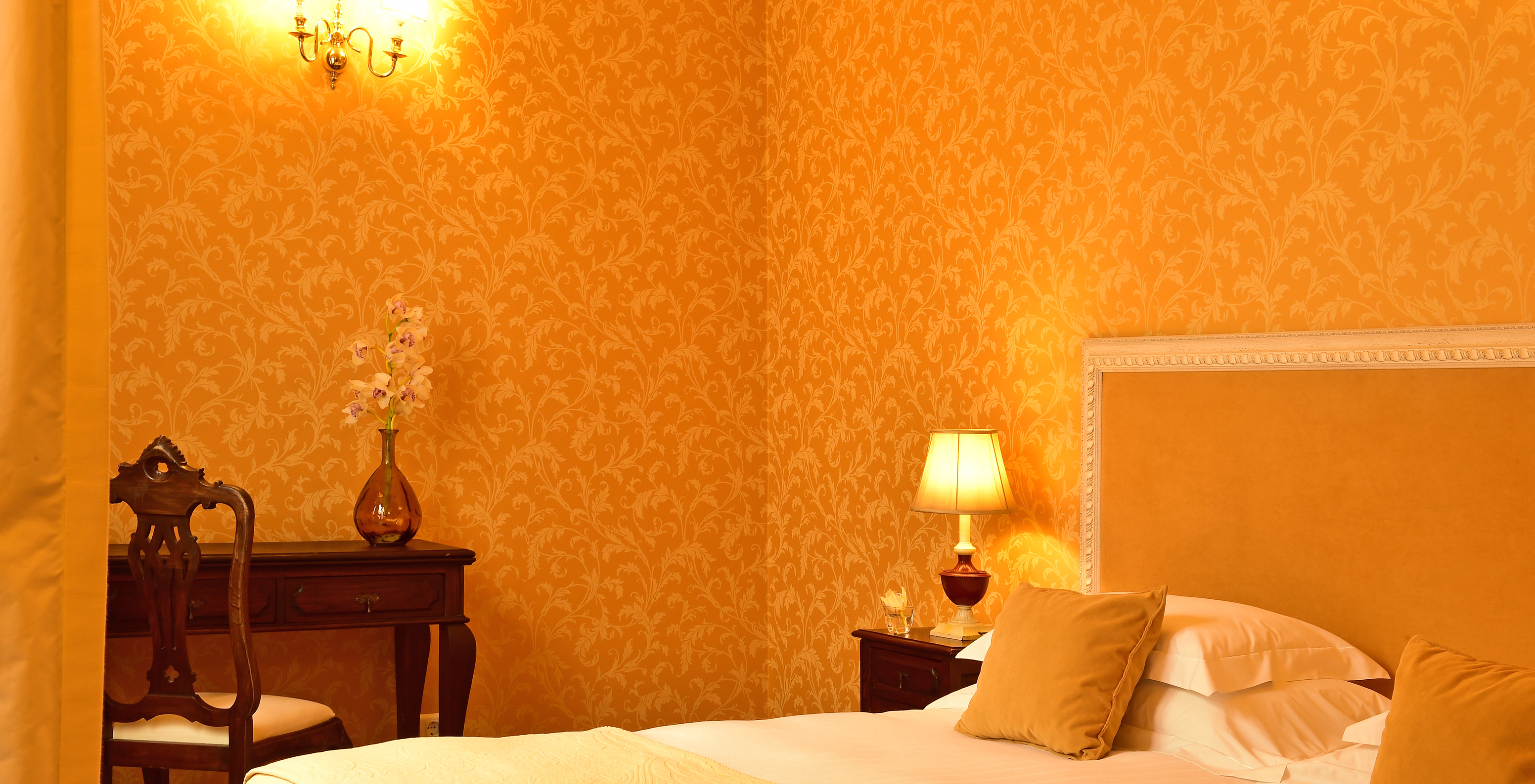 The Special Suite of The Pousada Convento Évora has a double bed with a bedside table and a desk