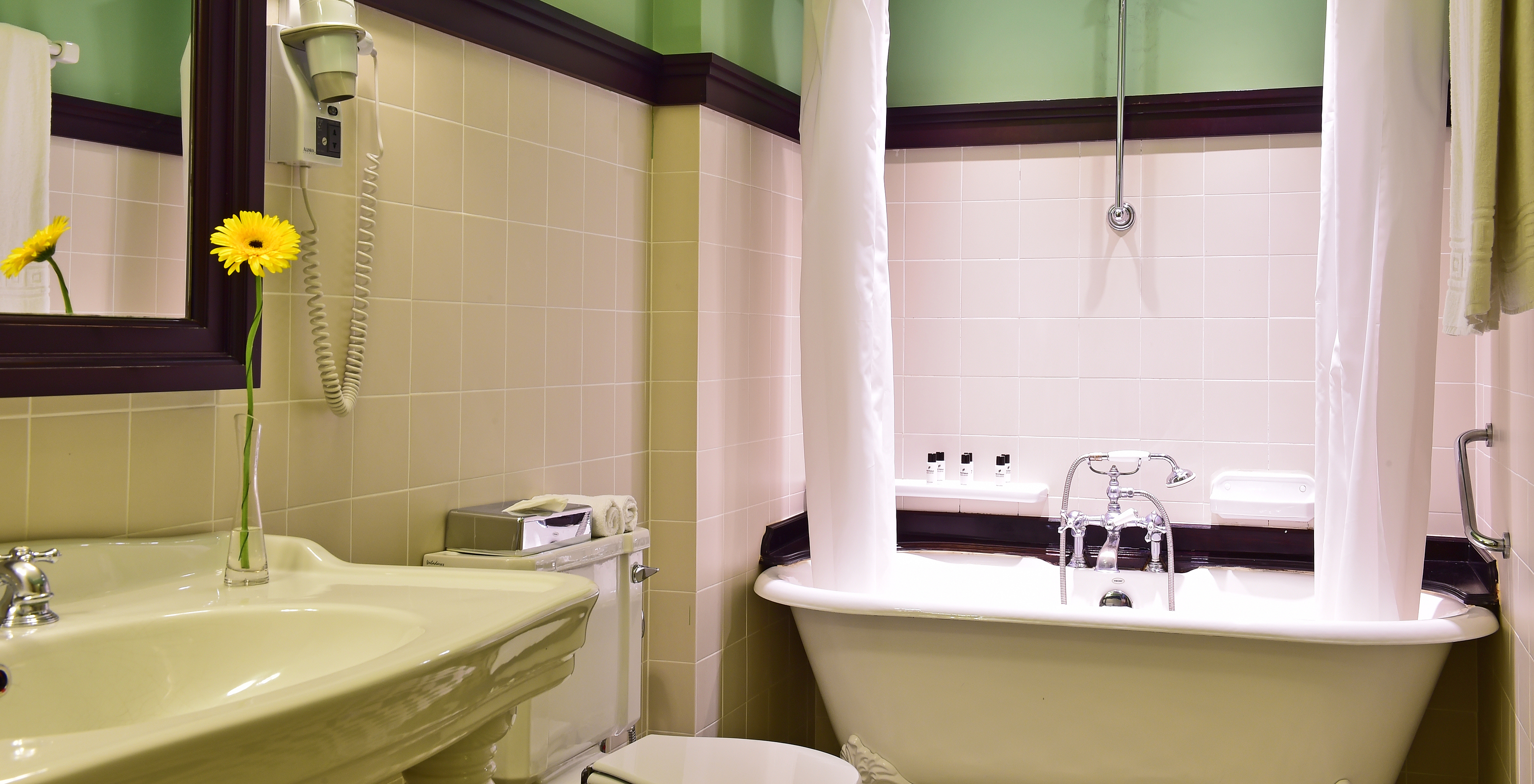 The Suite of The Pousada Convento Évora has a bathroom with a sink and a bathtub with a curtain