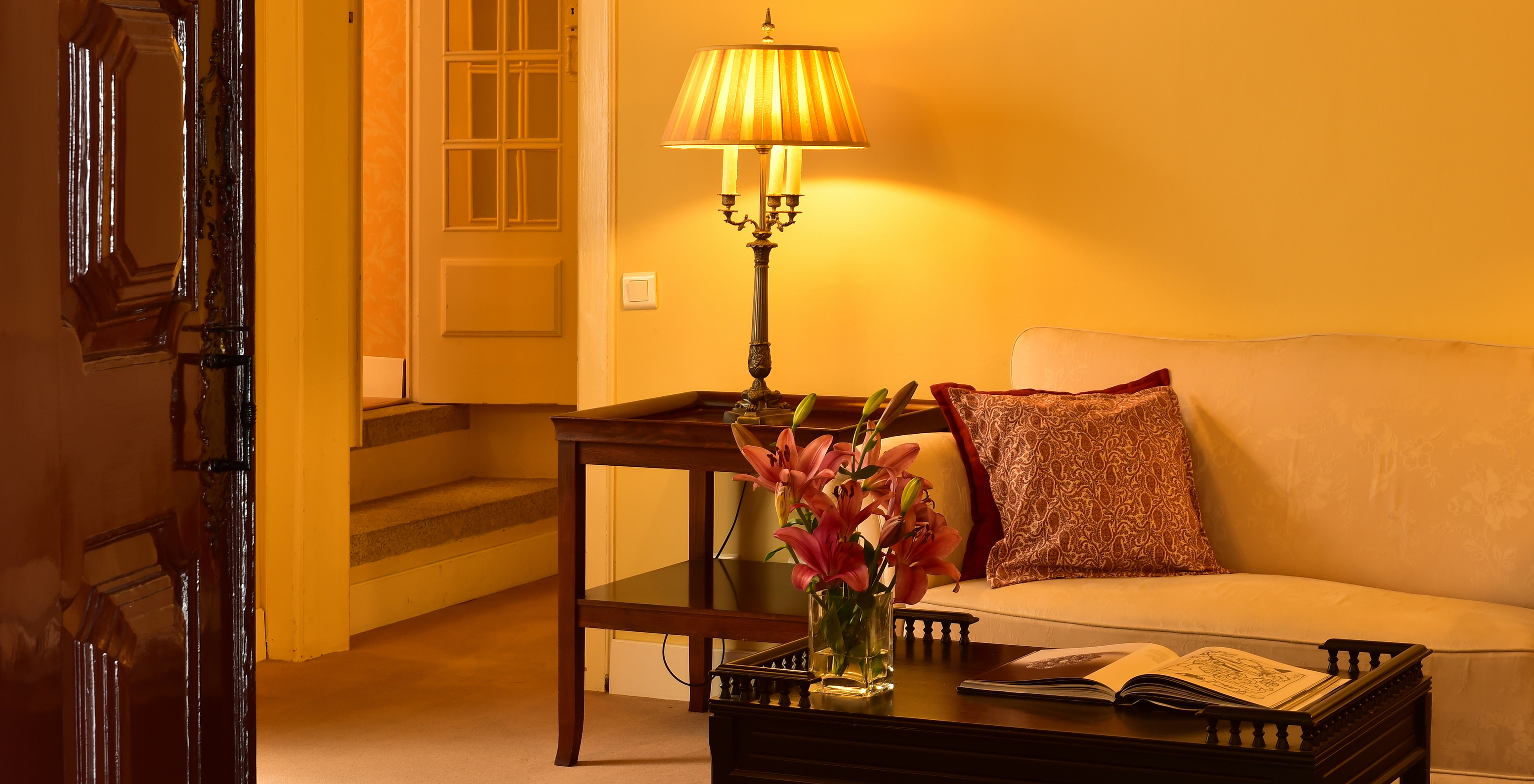 The Suite of The Pousada Convento Évora has a seating area with a sofa and a table with flowers