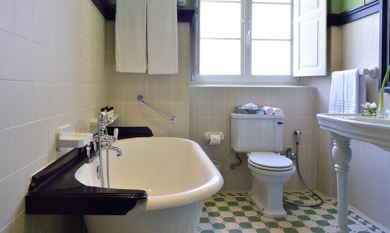 The Master Suite of The Pousada Convento Évora has a bathroom with a bathtub, toilet, and a window