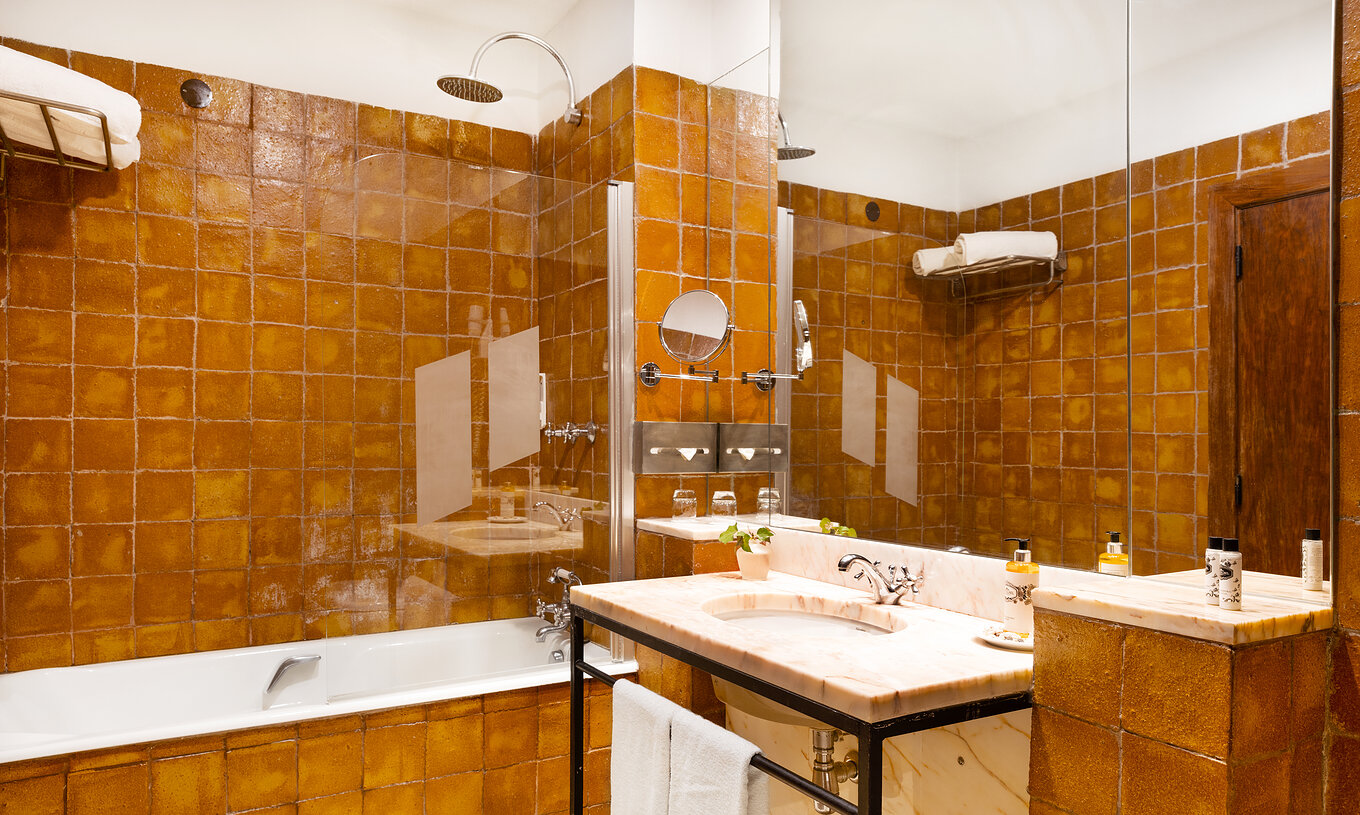 The Special Suite at Pousada Convento Vila Viçosa has a bathroom with bathtub, sink, mirror and towels