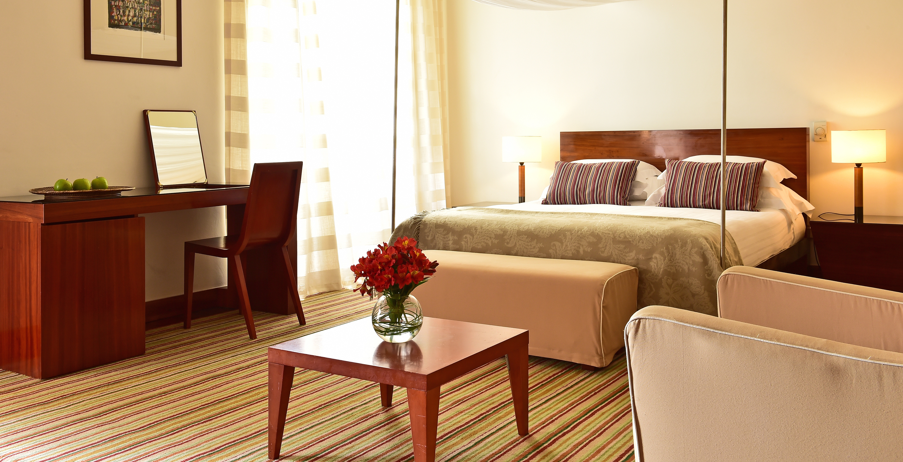The Historical Superior Room of The Pousada Mosteiro Crato has a double bed with a stool and a desk with a chair