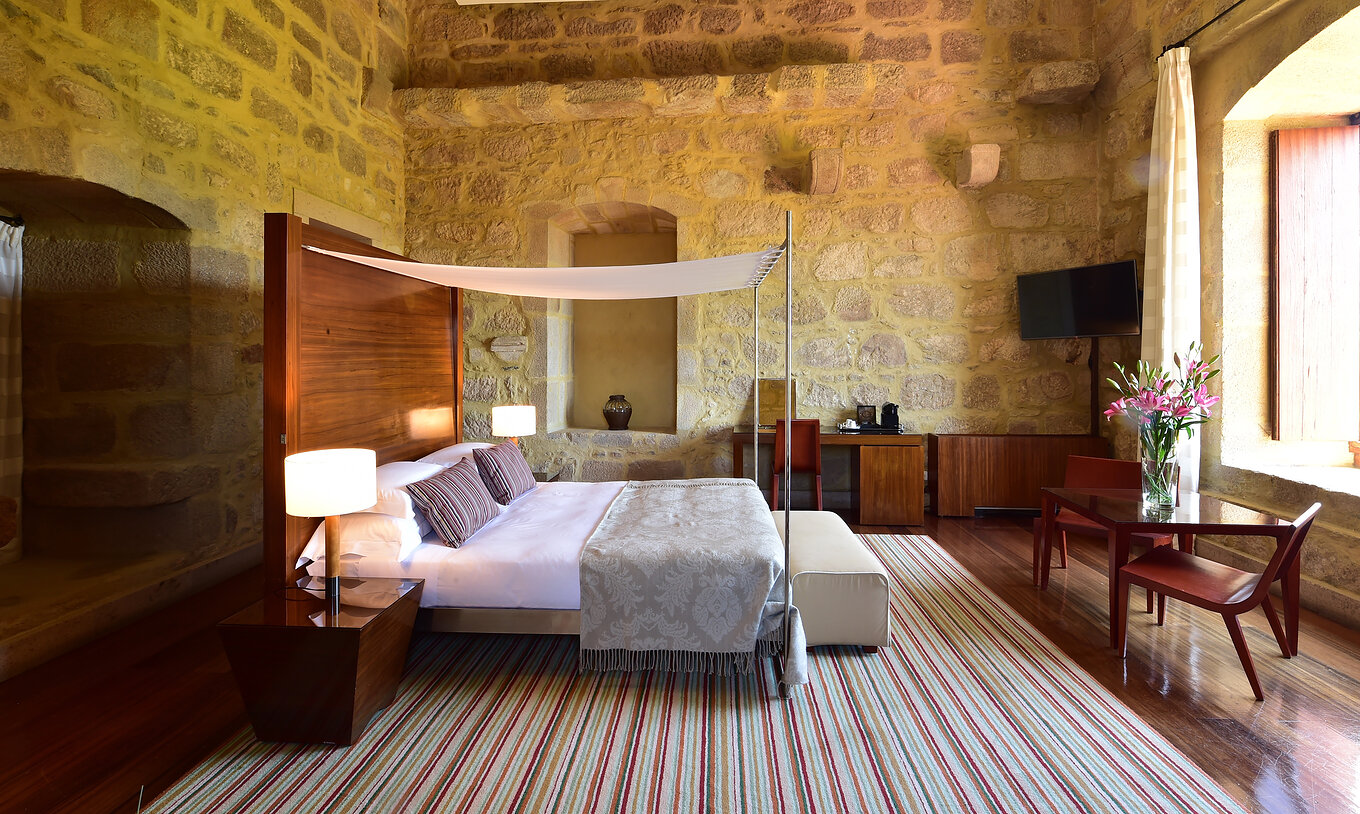 The Master Suite of The Pousada Mosteiro Crato is spacious with a four-poster double bed and also has a desk and a television