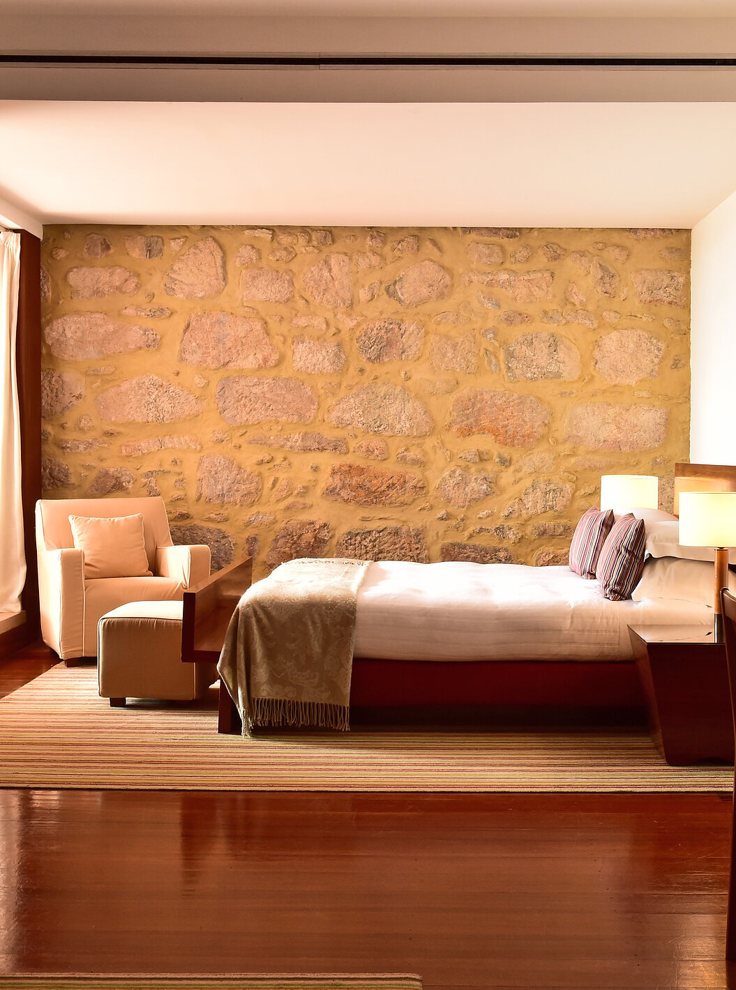 The Standard Suite of The Pousada Mosteiro Crato has a double bed with an armchair, TV, desk, and a small fireplace
