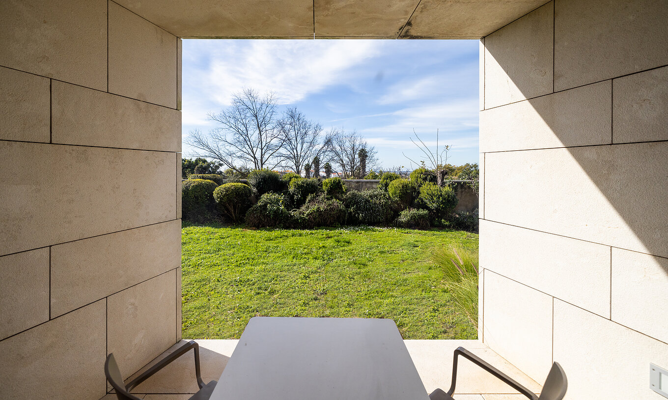 The Classic Room at Pousada Palácio Estoi has a balcony overlooking a lawn with two chairs and a table