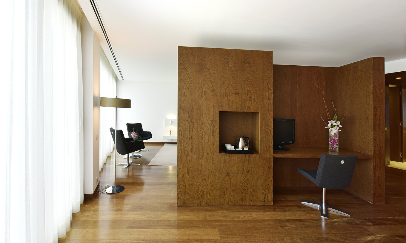 The Special Suite of The Pousada Palácio Estoi has a desk with a vase of flowers and a television monitor