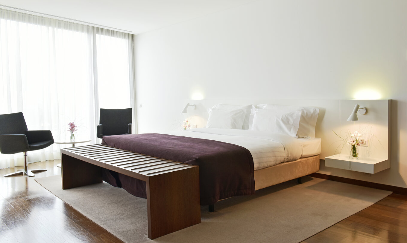 The Standard Suite of The Pousada Palácio Estoi has a double bed, two bedside tables, and a table with two chairs