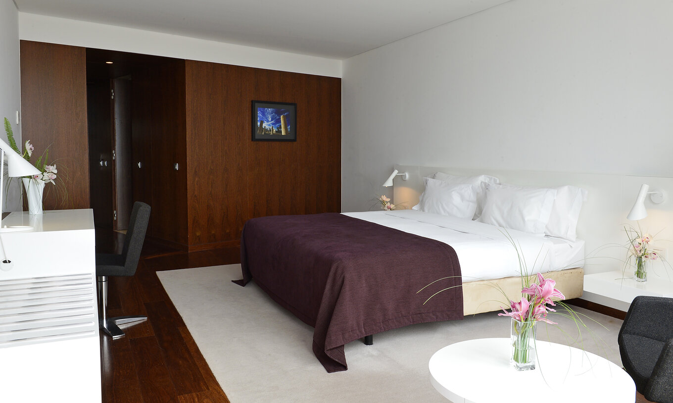 The Superior Room of The Pousada Palácio Estoi has a double bed, two bedside tables, and a picture on the wall