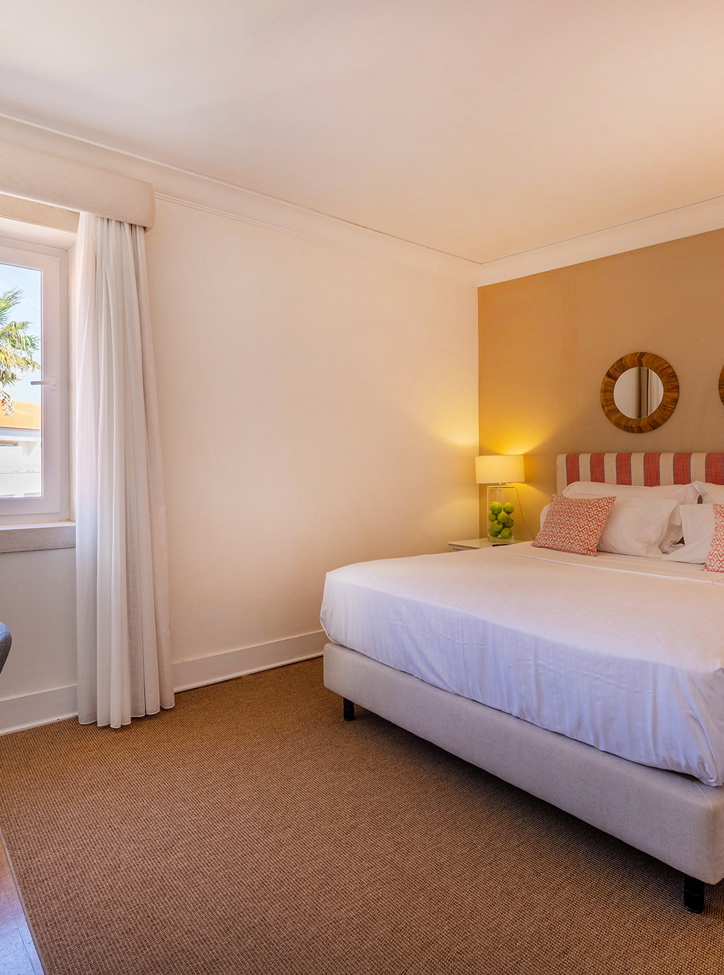 The Classic Room of Pousada Sagres has two beds with striped headboards, two mirrors, a window, and a desk