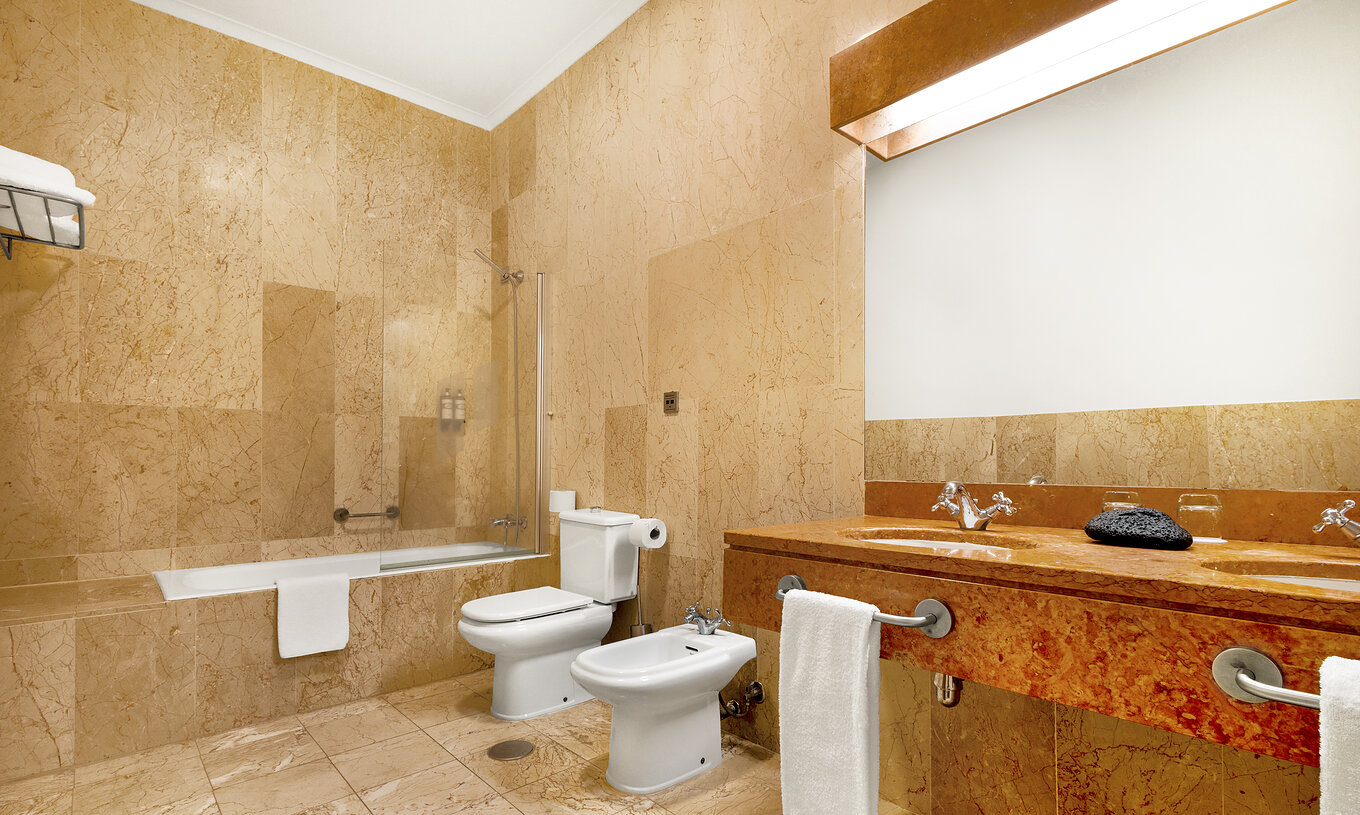 The Standard Suite of The Pousada Forte Horta has a bathroom with bathtub with shower, and sink with mirror