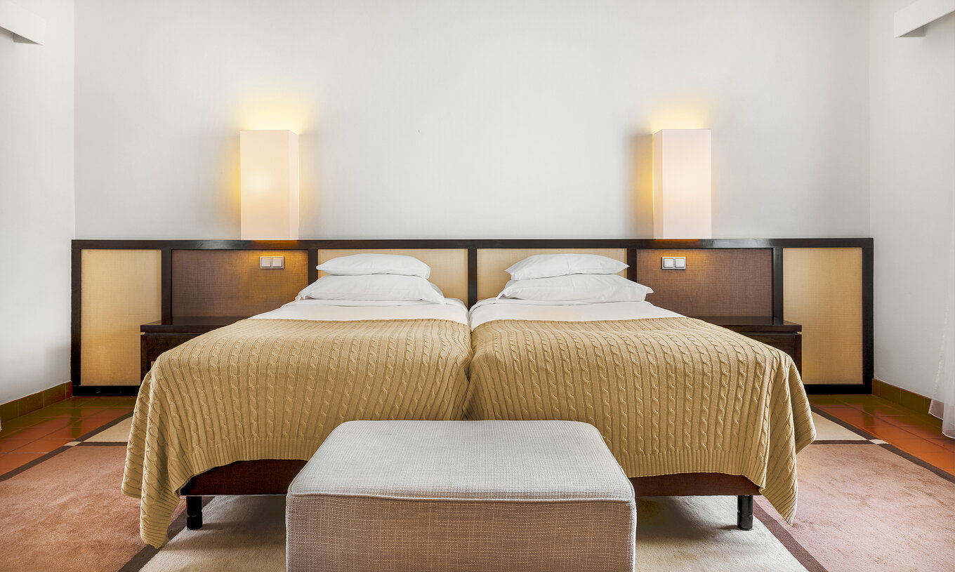 The Standard Suite of The Pousada Forte Horta has two single beds, with a bedside table with lamp
