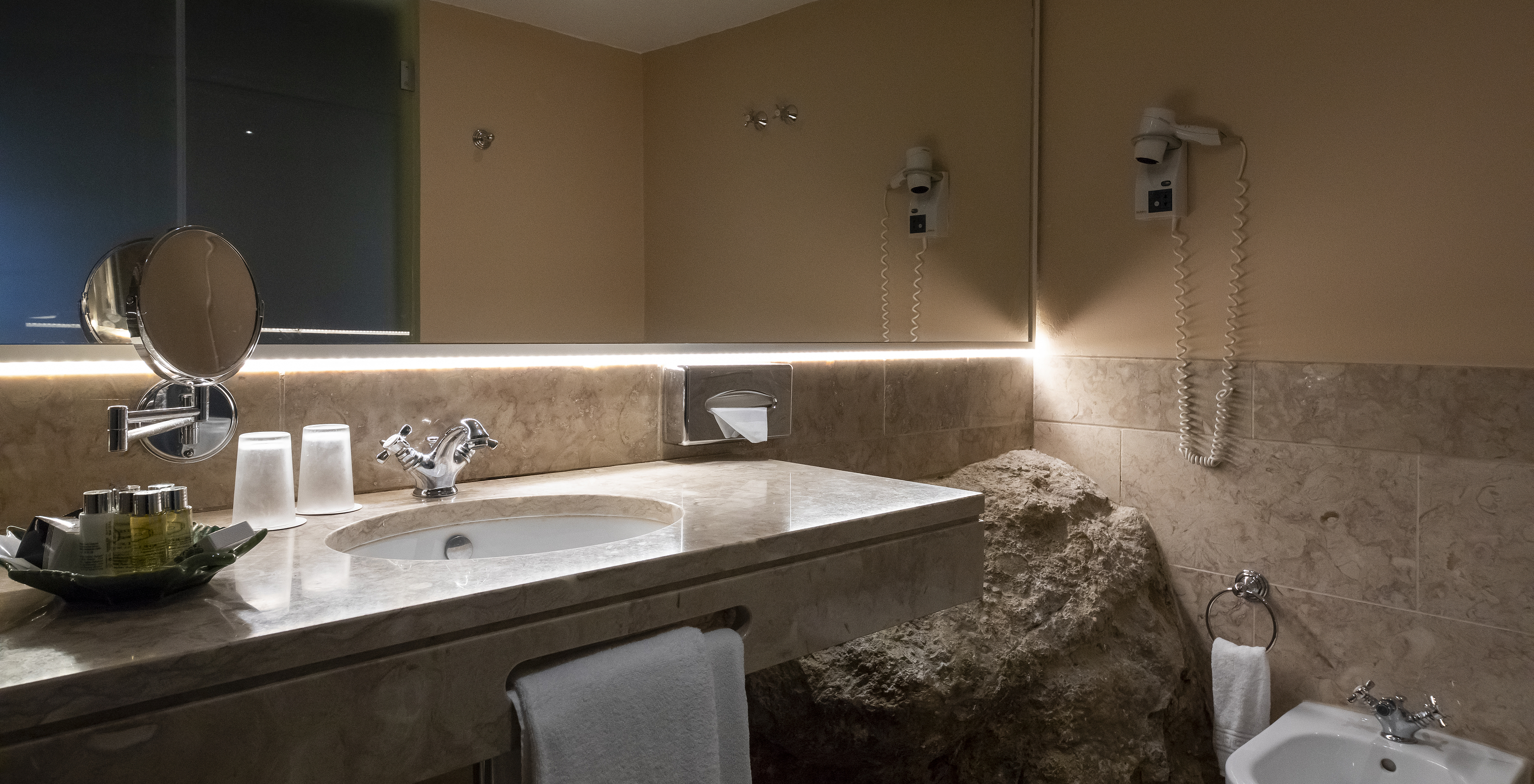 The Suite Cottage at Pousada Castelo Óbidos has a bathroom with mirror, sink, and hairdryer