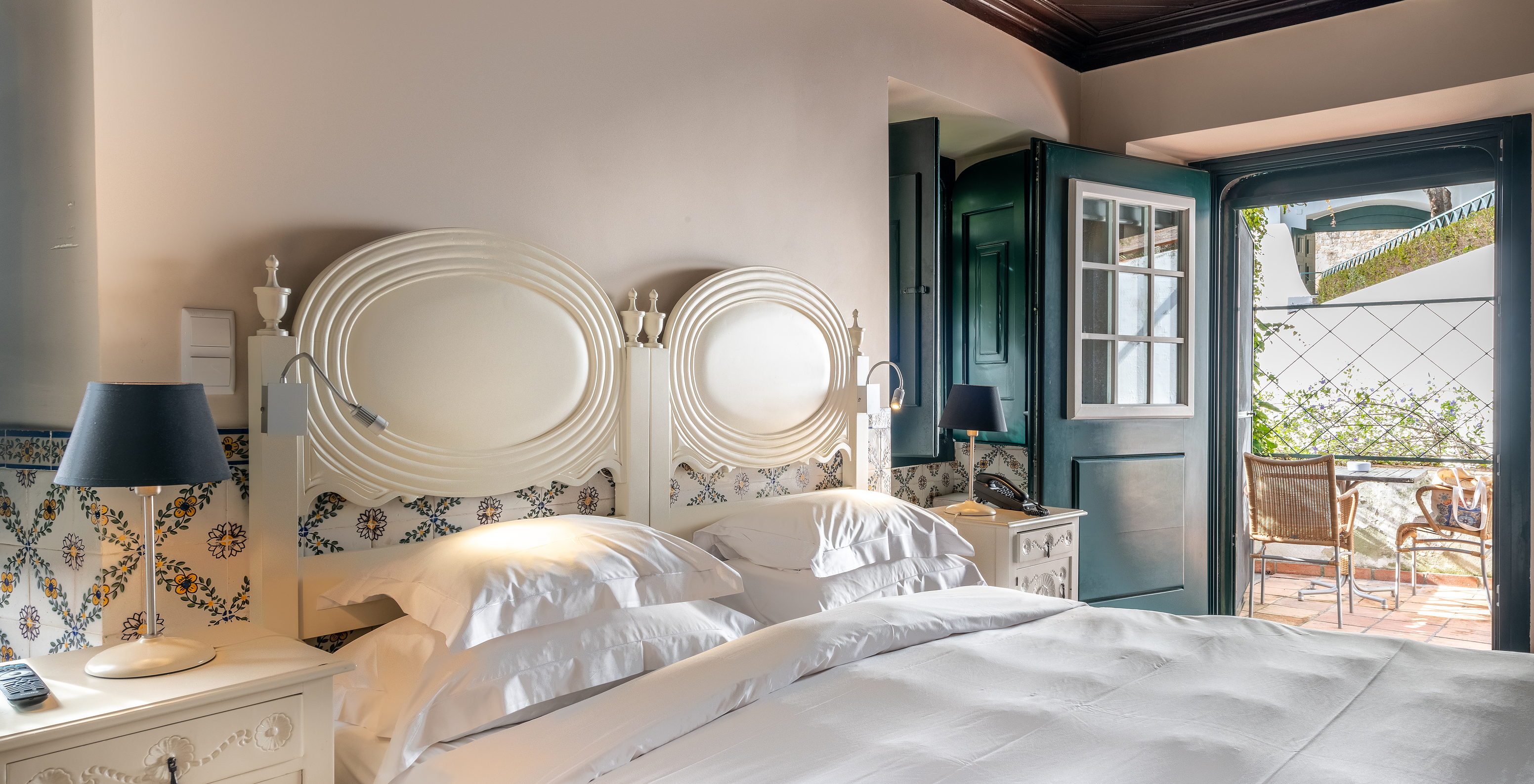 The Superior Room with Balcony Cottage at Pousada Castelo Óbidos has a double bed with a bedside table