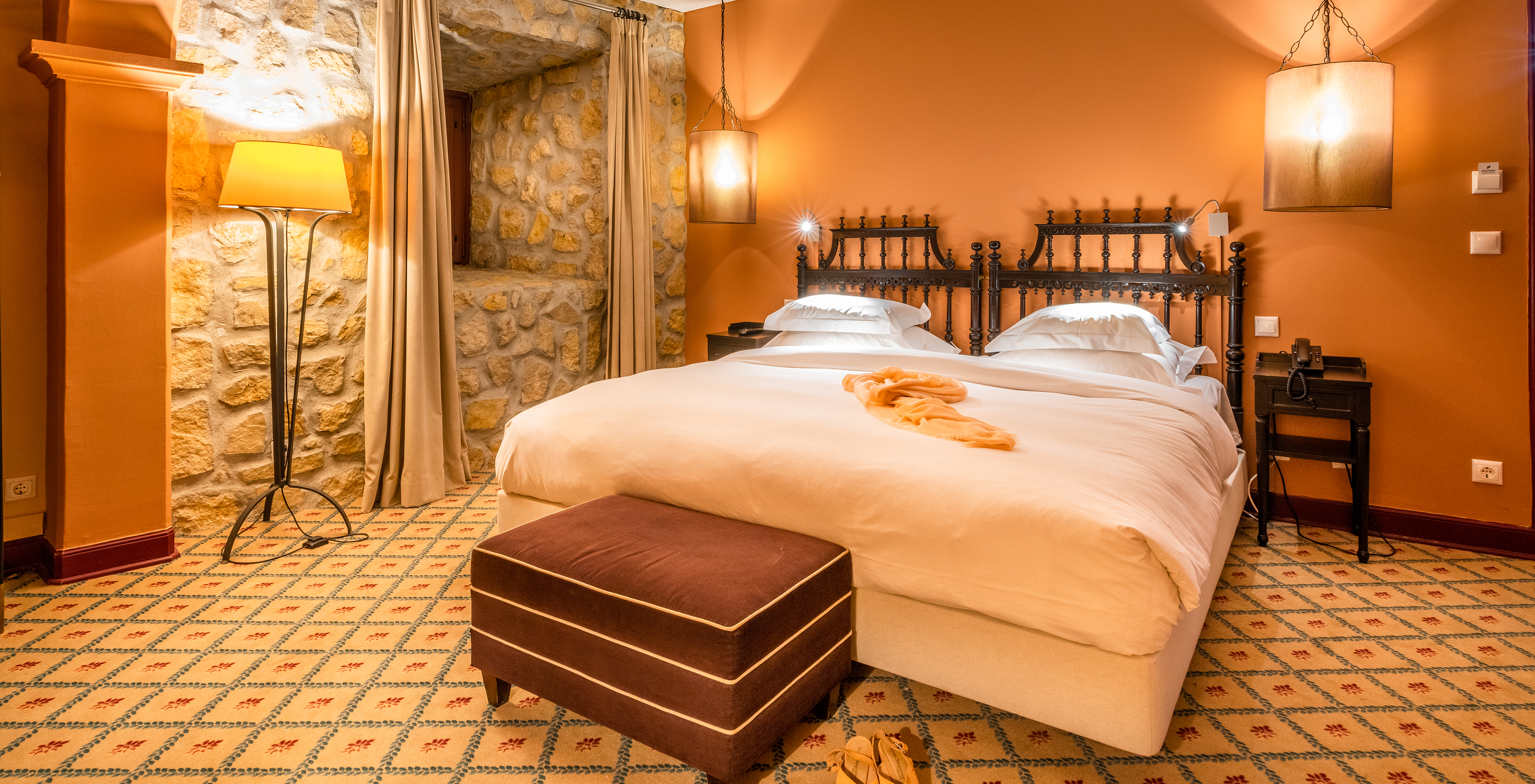 The Superior Room Castle at Pousada Castelo Óbidos has a double bed with a bedside table and phone