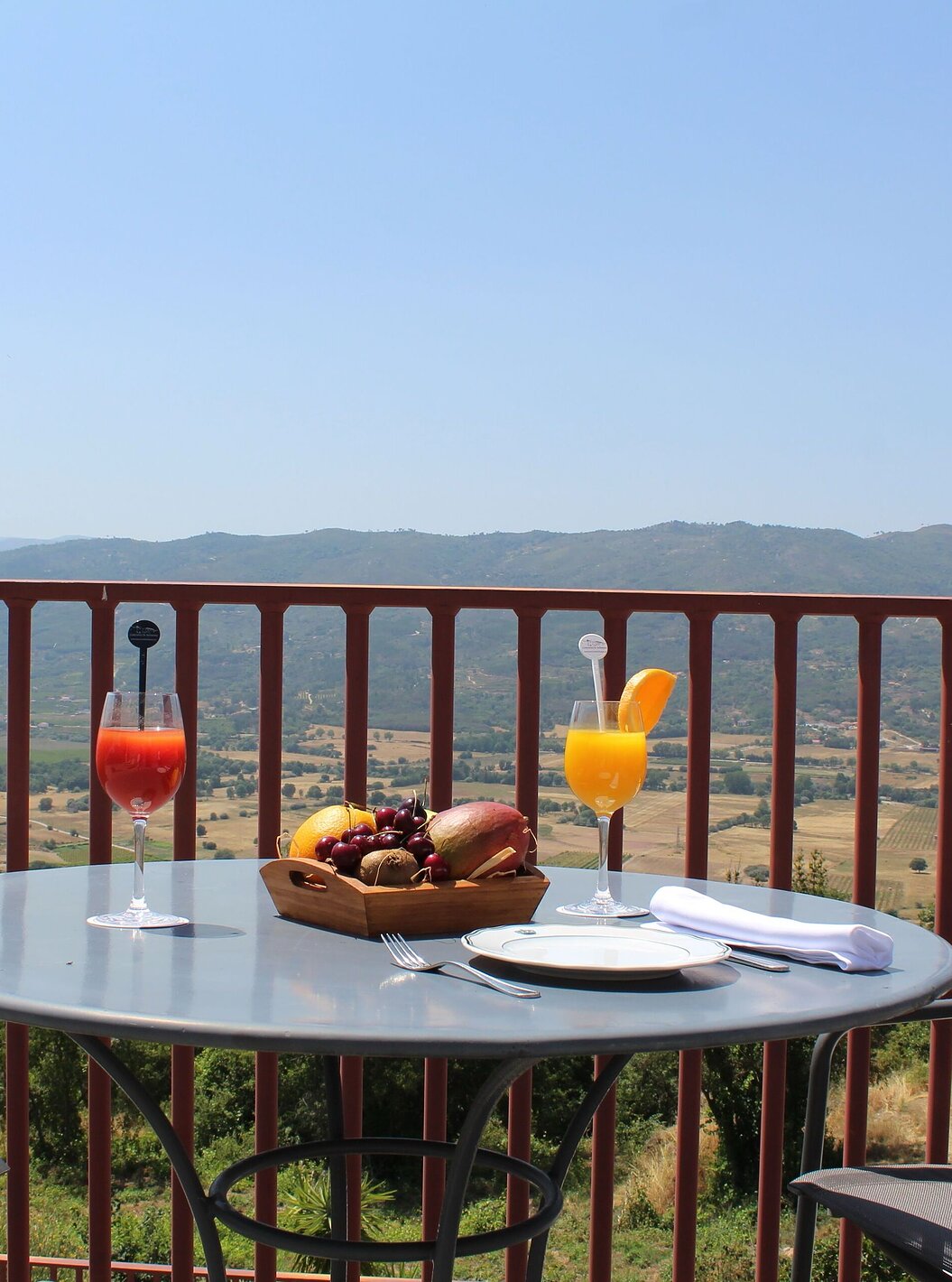 The Twin Room with Balcony of The Pousada Convento de Belmonte has a table set with two juices and an impressive view