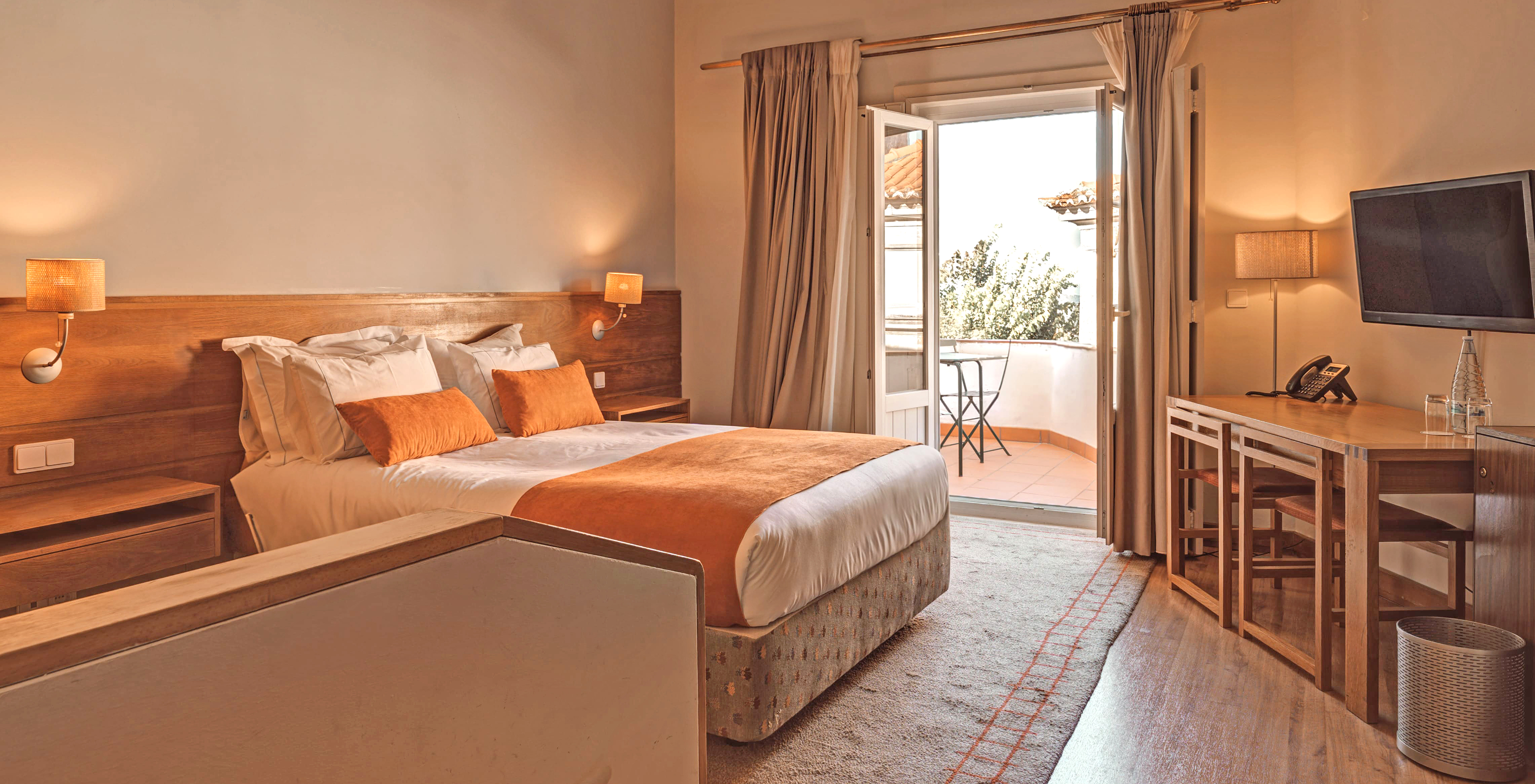 The Superior Balcony Room of The Pousada Ourém has a double bed and access to a balcony with a table and chair