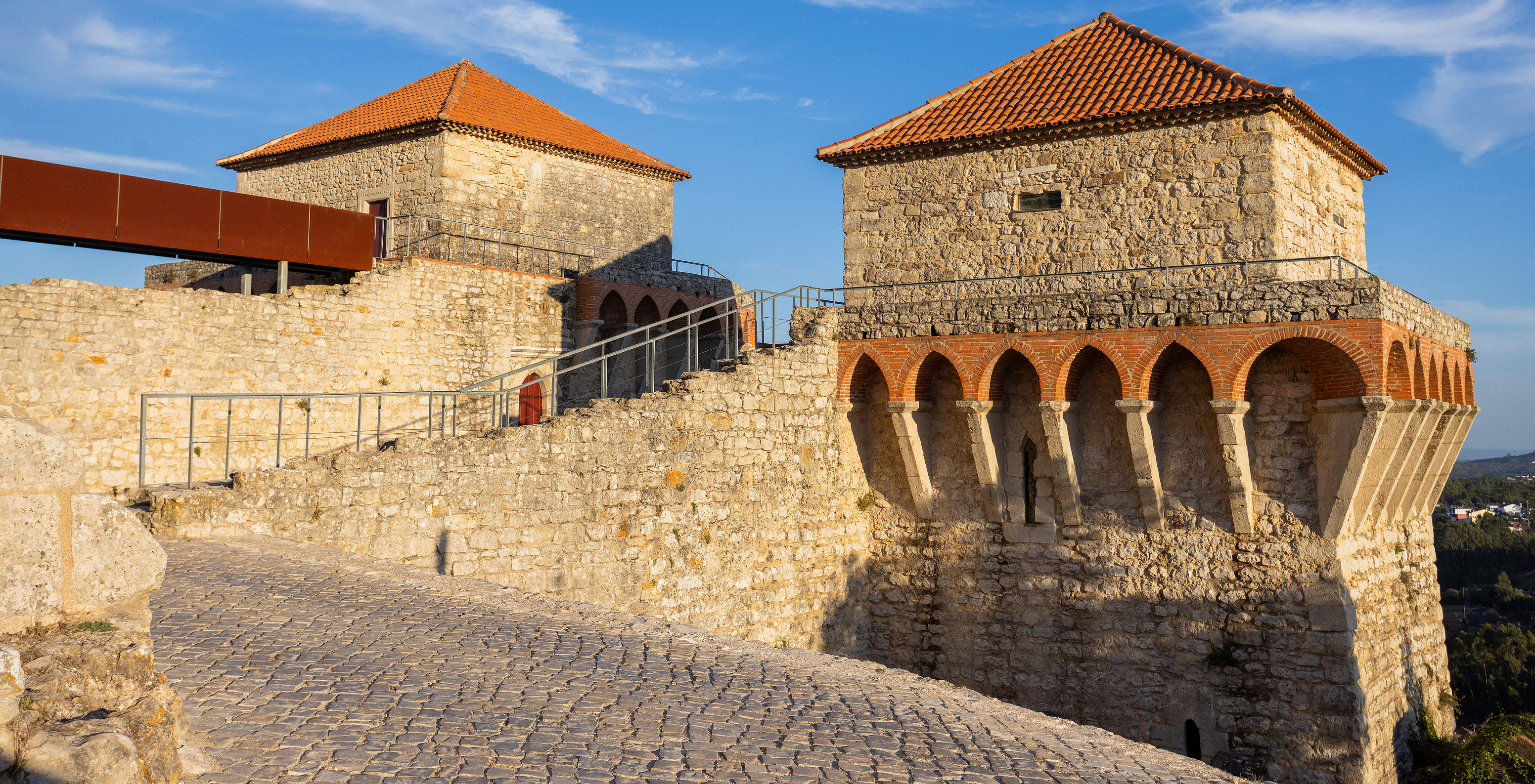 Two stone towers with stairs in between at Pousada Ourém, with a balcony around