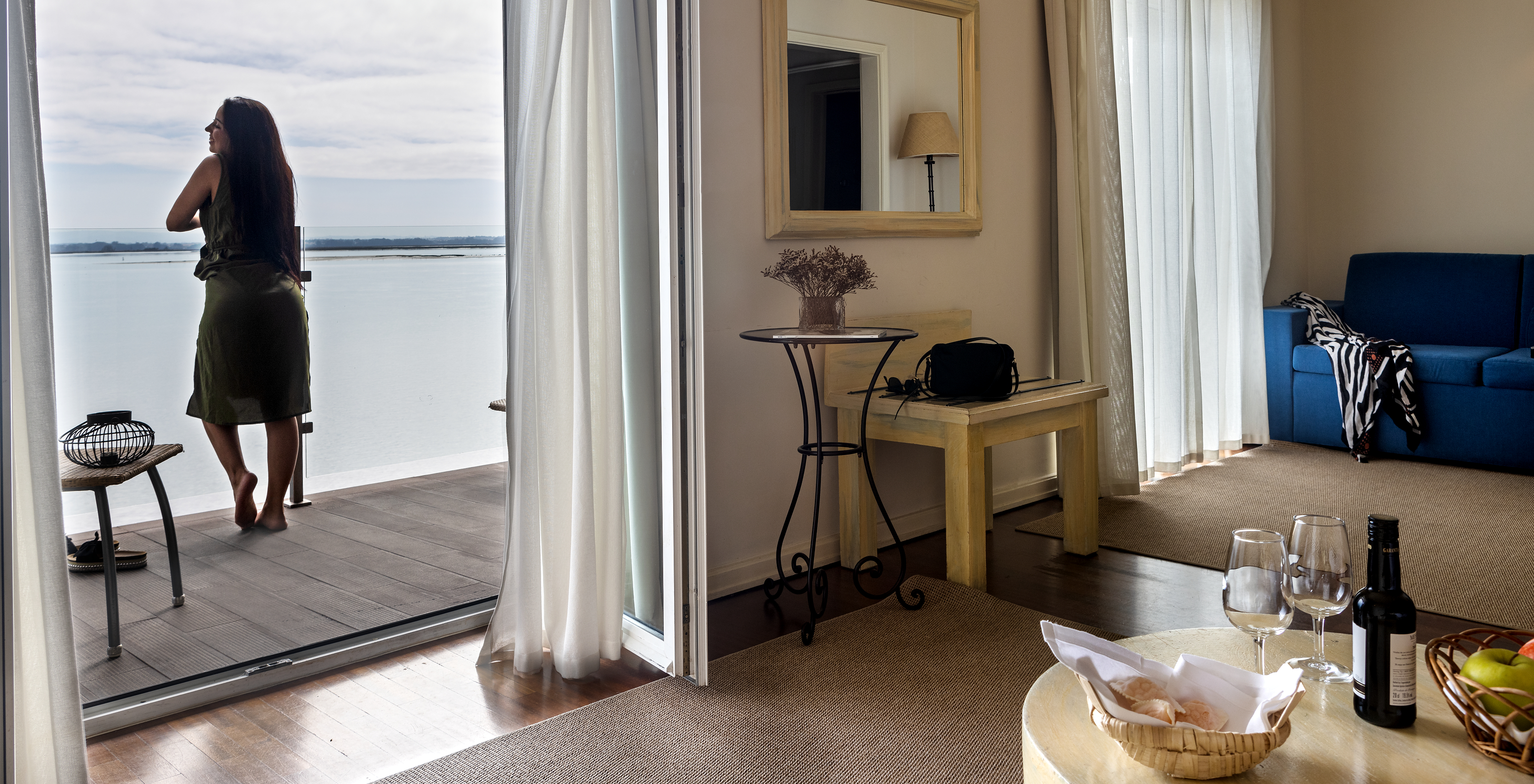 The Junior Suite of The Ria Inn - Aveiro has a living room with sofa, table, and a balcony with panoramic view of the ria