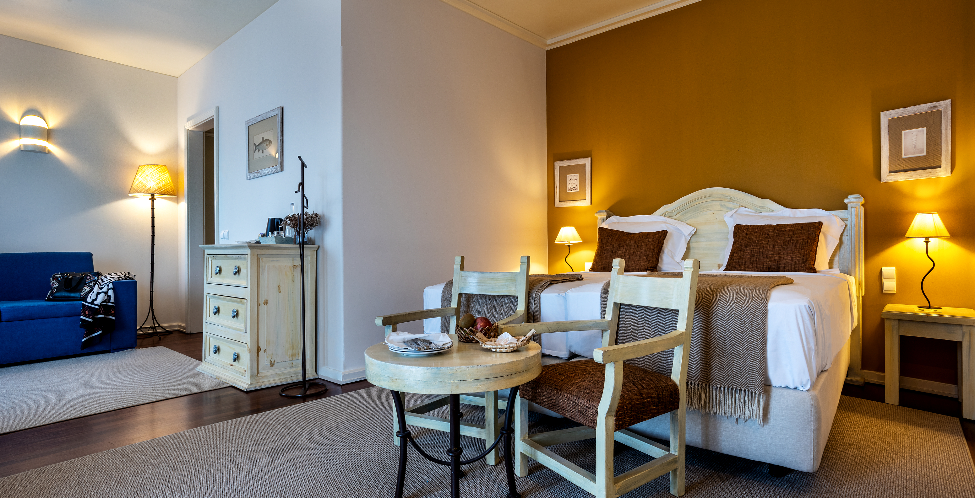 The Junior Suite of The Ria Inn - Aveiro has a double bed, table, chairs, sofa, and a wardrobe