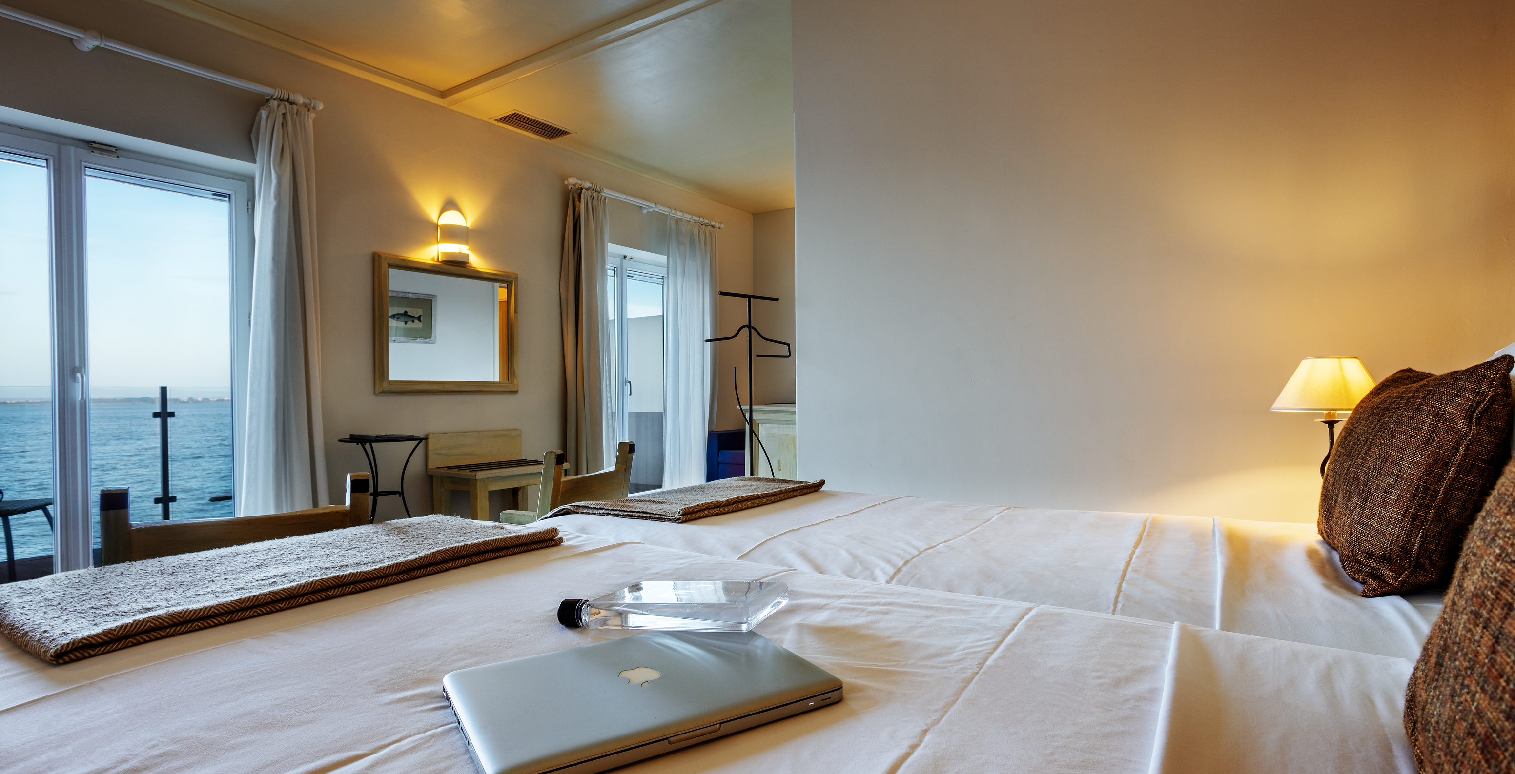 The Junior Suite of The Ria Inn - Aveiro has a panoramic view of the ria, two single beds, and a mirror