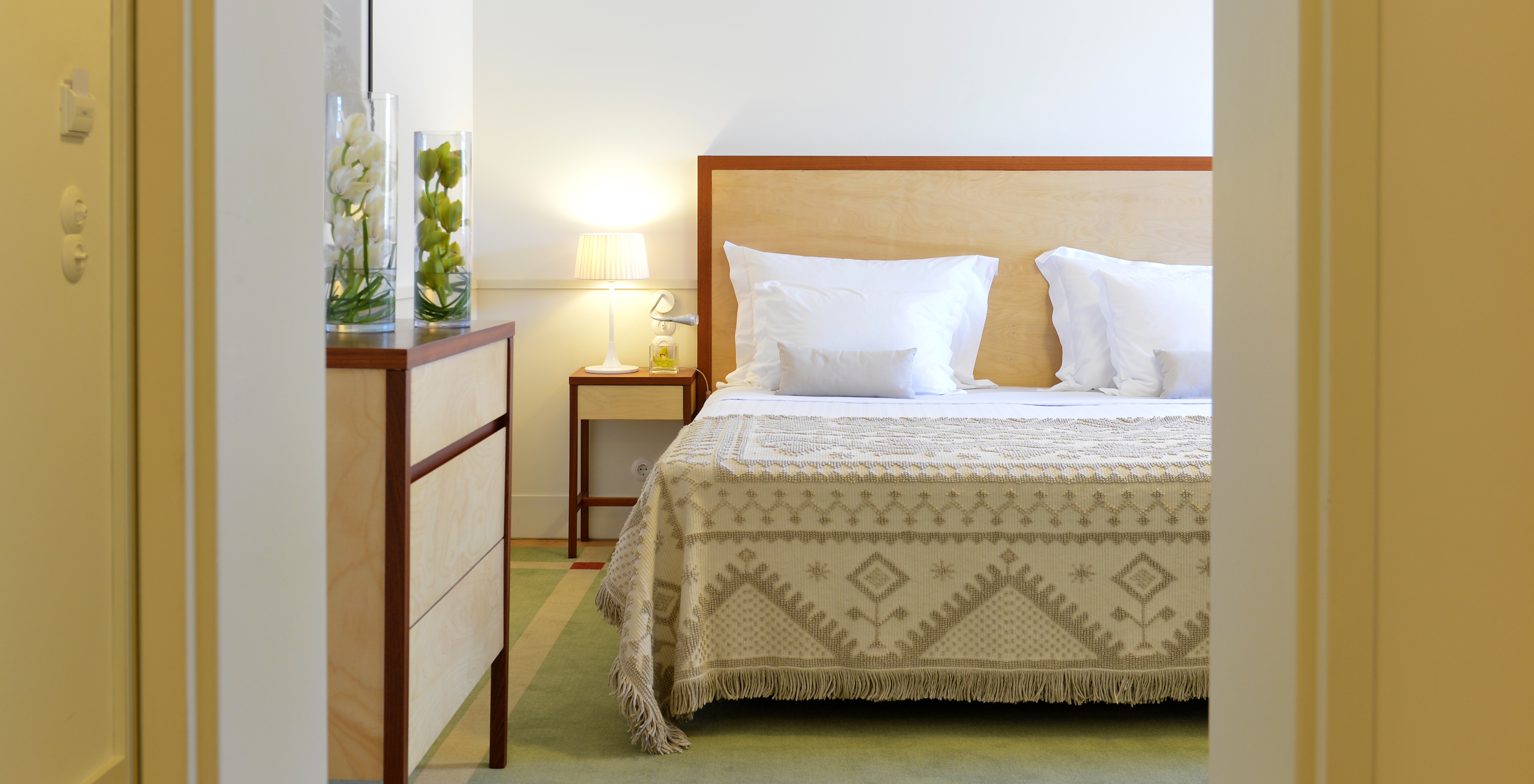 The Superior Family of The Pousada Serra da Estrela has a double bed with a wooden headboard and a wooden piece of furniture