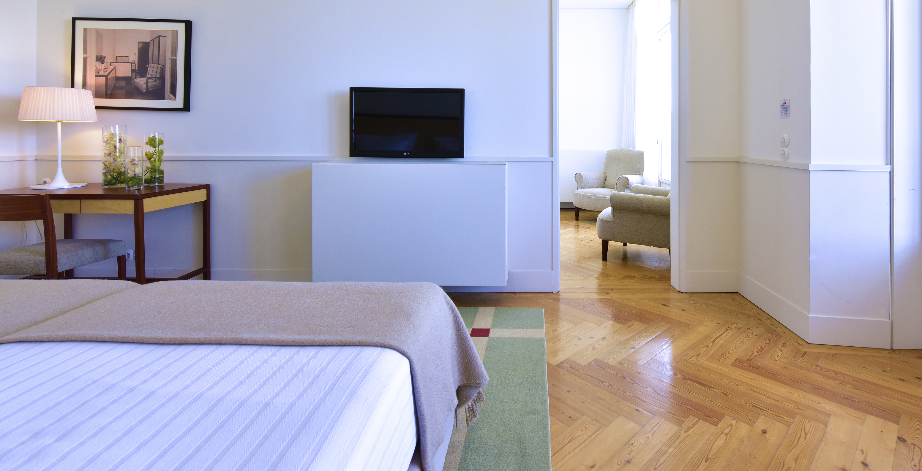The Superior Family of The Pousada Serra da Estrela has a bedroom with two beds, a television in front, and a desk