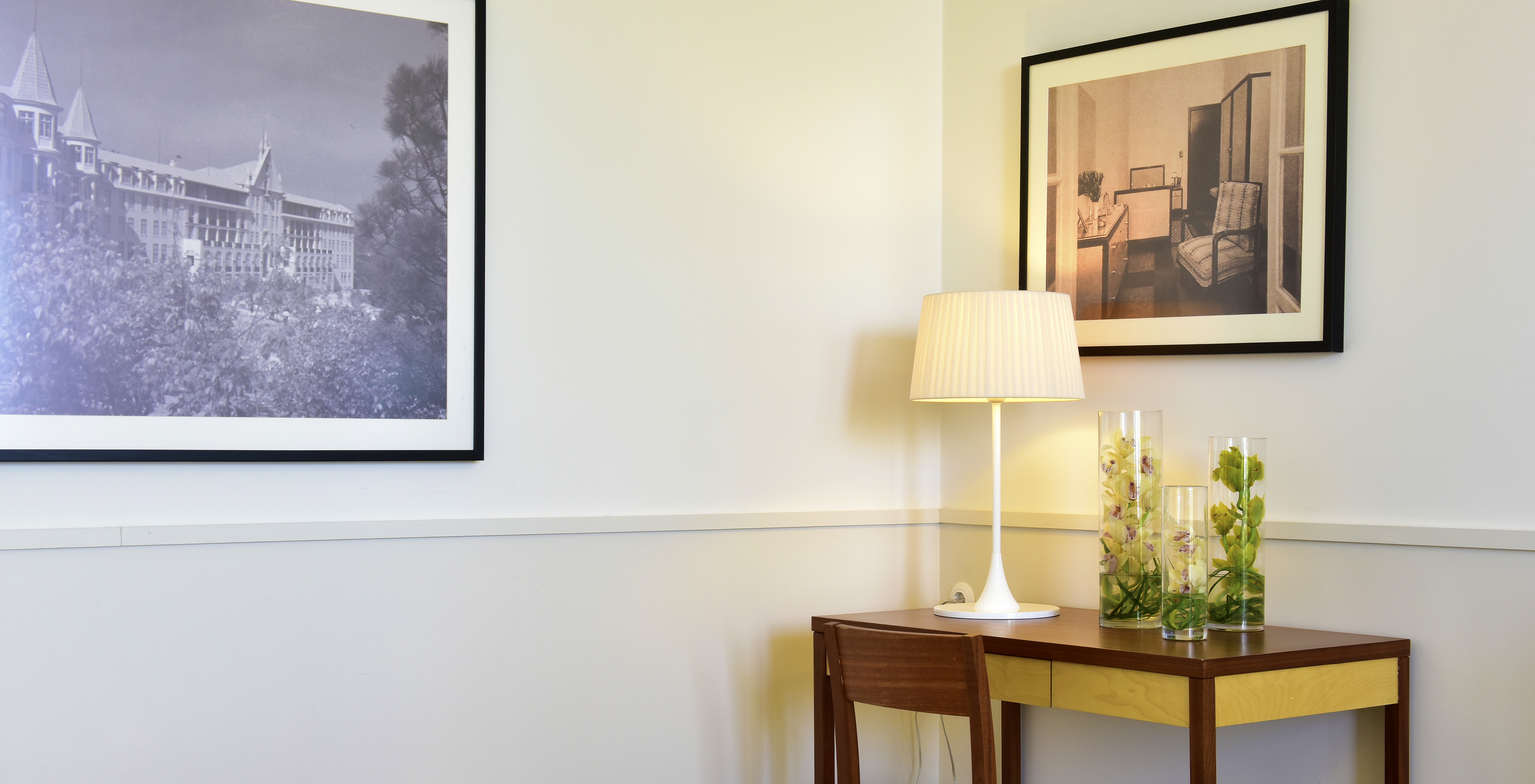 The Superior Room of The Serra da Estrela Inn has a desk and two paintings of the old sanatorium of Serra da Estrela